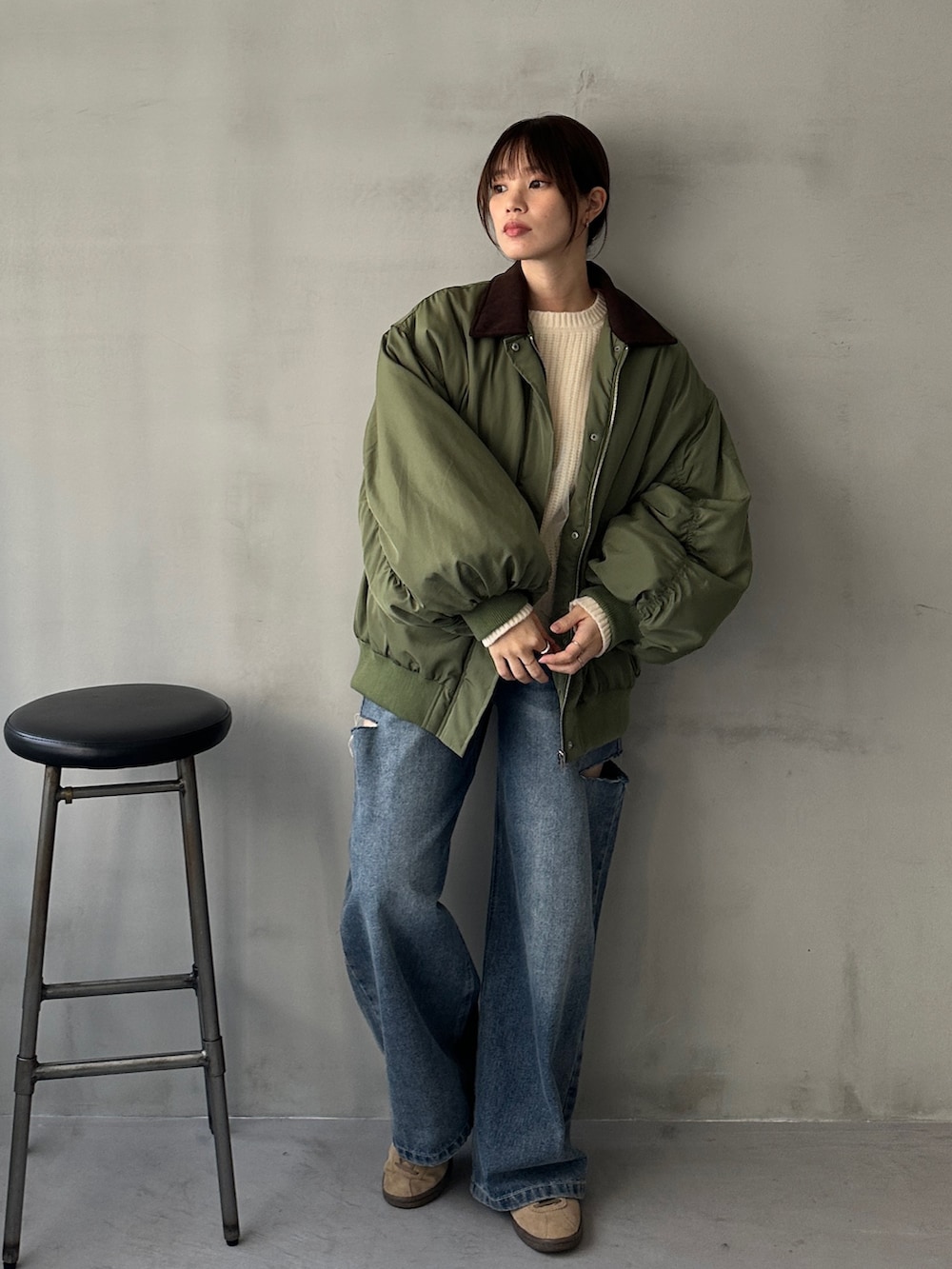 ブルー系のデニムパンツ、グリーン系のMA-1、ホワイト系のニット/セーターを着用したレディースの冬コーディネートの4枚目の写真