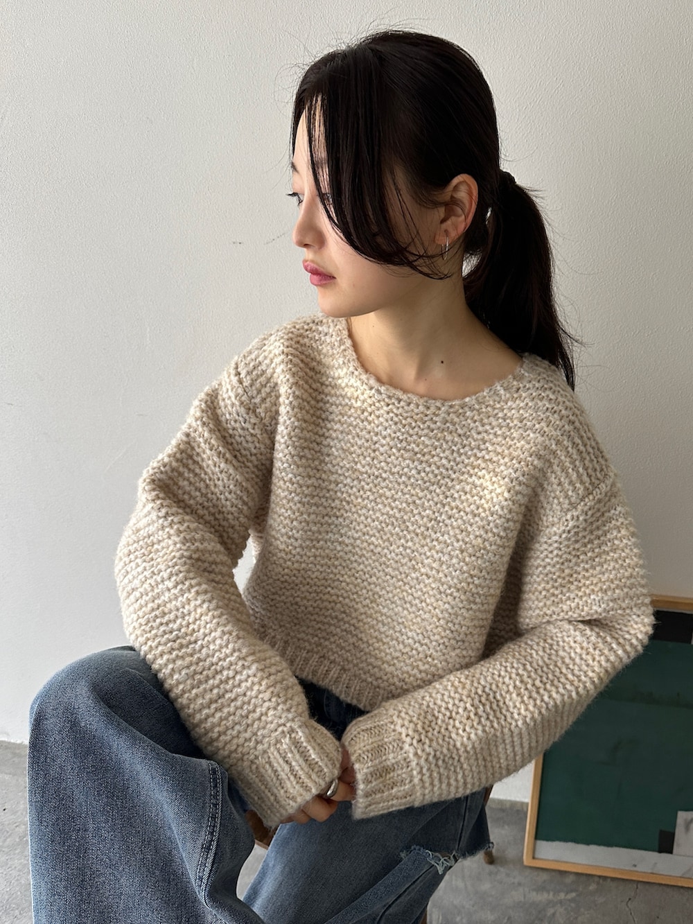 ホワイト系のニット/セーター、ブルー系のデニムパンツ、ベージュ系のスニーカーを着用したレディースの冬コーディネートの4枚目の写真
