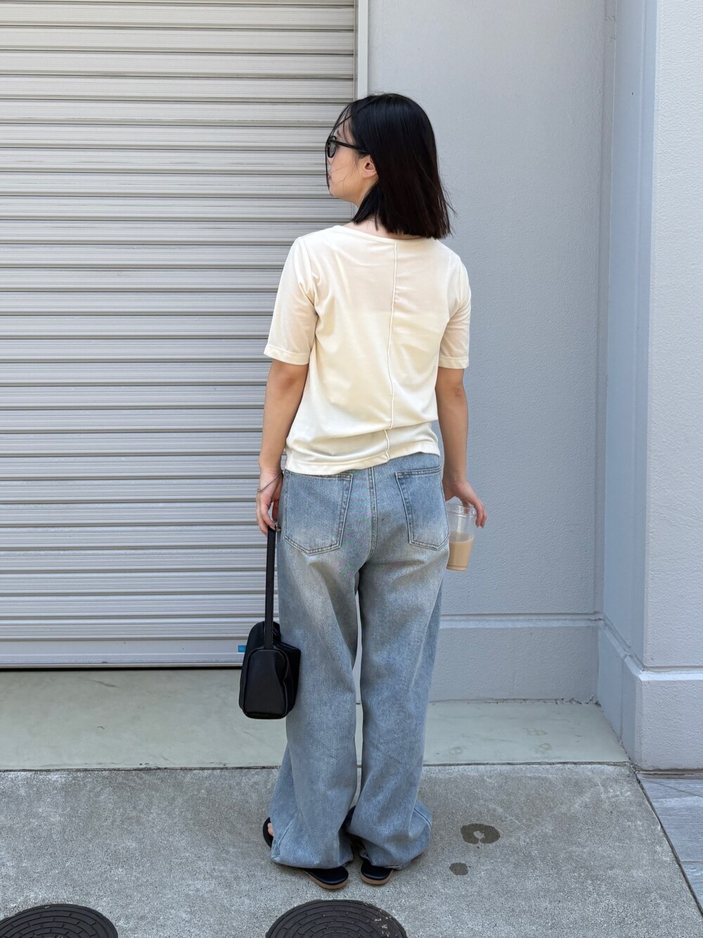 ホワイト系のTシャツ/カットソー、ブラック系のショルダーバッグ、ブルー系のデニムパンツを着用したレディースの夏コーディネートの3枚目の写真