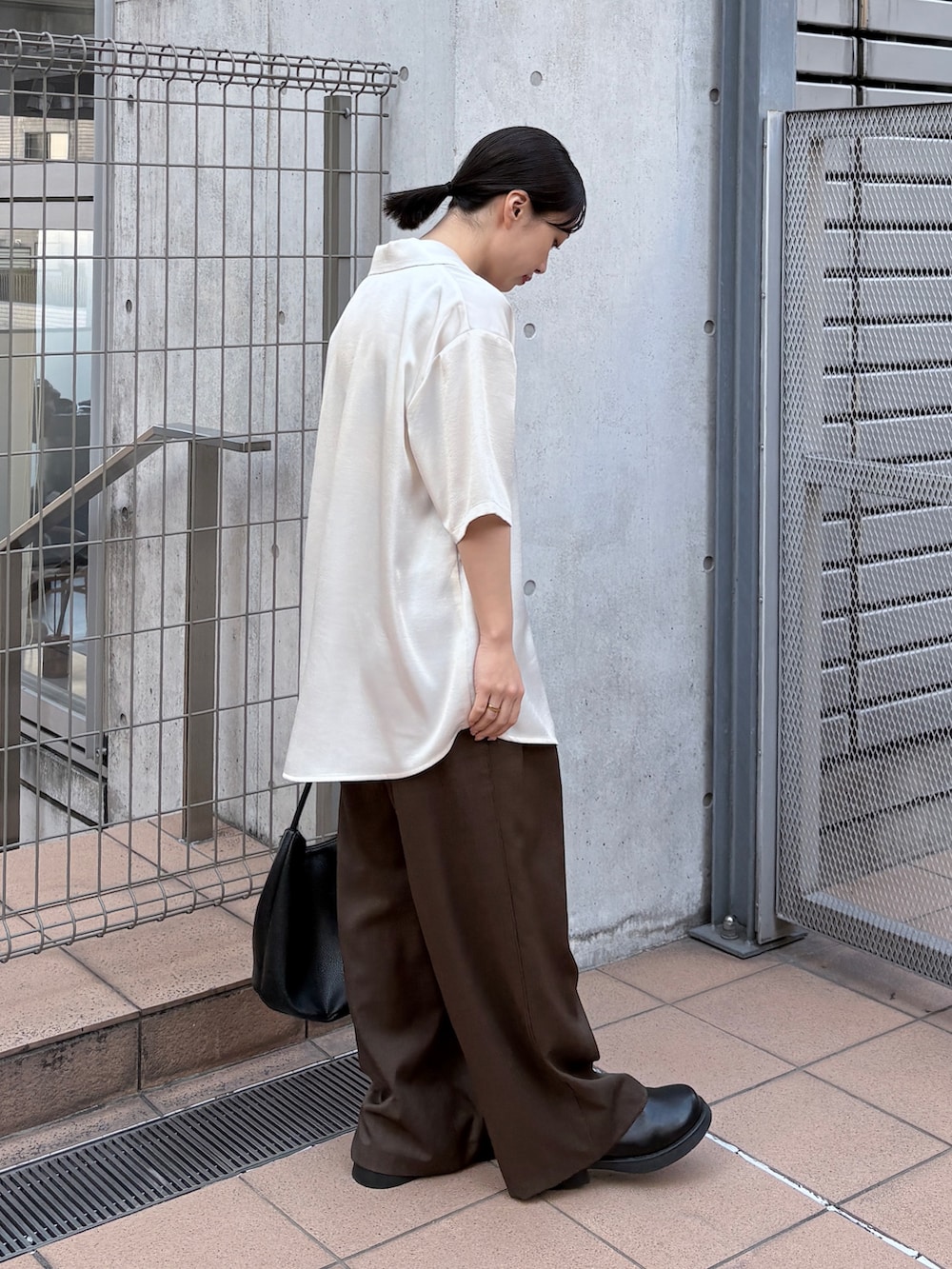 ホワイト系のシャツ/ブラウス、ブラウン系のスラックス、ブラック系のその他シューズを着用したレディースの春コーディネートの2枚目の写真