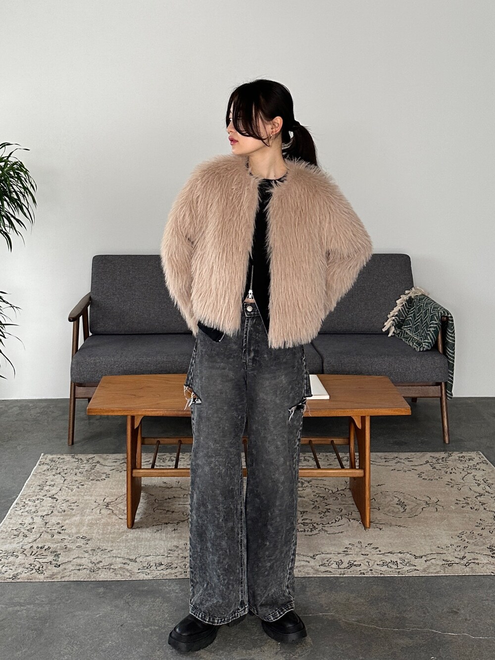 ブラック系のデニムパンツ、ベージュ系のその他アウター、ブラック系のニット/セーターを着用したレディースの冬コーディネートの3枚目の写真