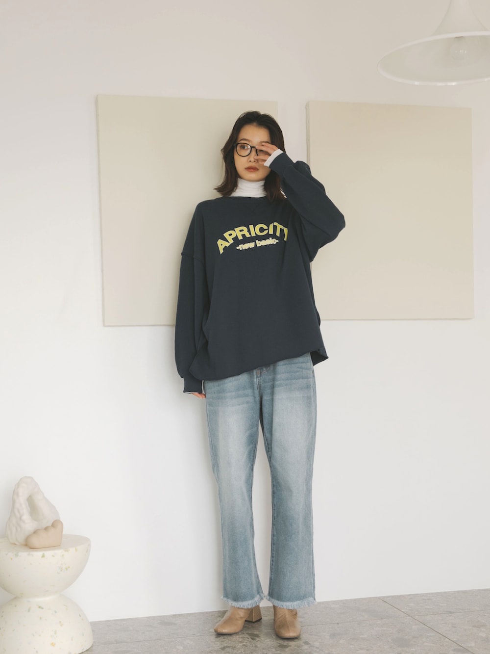 ブルー系のスウェット、ホワイト系のTシャツ/カットソー、ブルー系のデニムパンツを着用したレディースの秋コーディネートの2枚目の写真