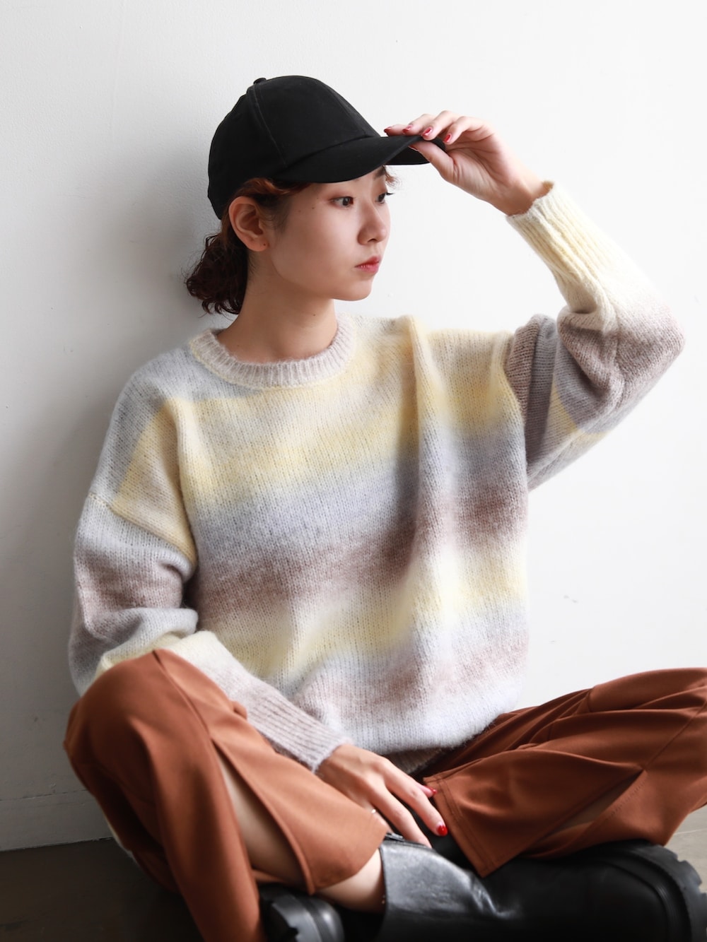 イエロー系のニット/セーター、ブラウン系のスラックス、その他のその他を着用したレディースの冬コーディネートの2枚目の写真