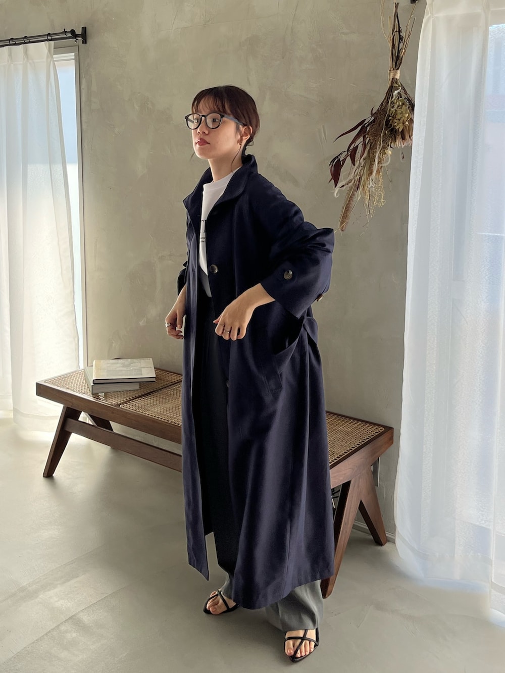 ブルー系のトレンチコート、ホワイト系のスウェット、グレー系のスラックスを着用したレディースの冬コーディネートの3枚目の写真