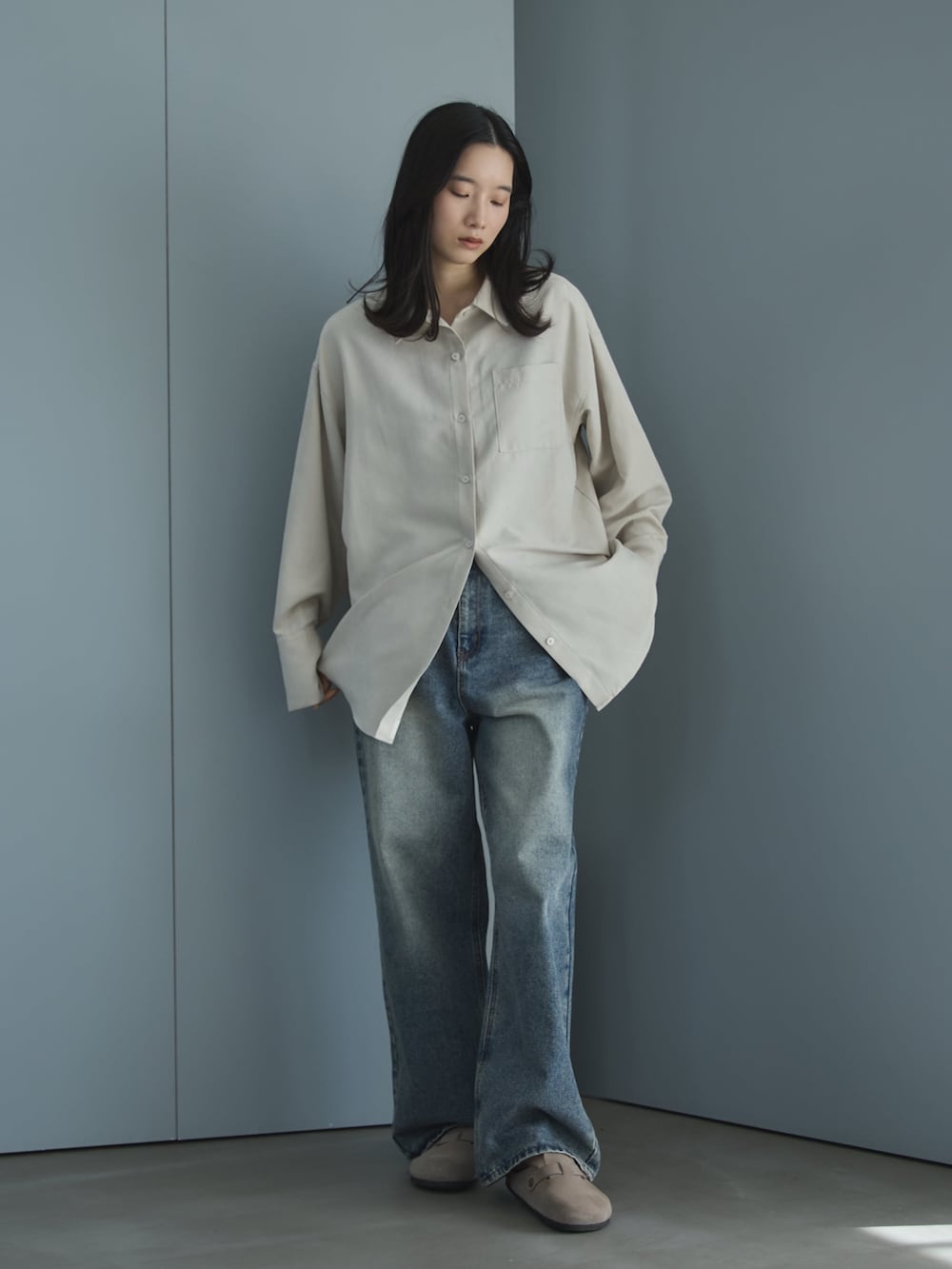 ブルー系のデニムパンツ、ホワイト系のシャツ/ブラウス、ベージュ系のサンダルを着用したレディースの春コーディネートの2枚目の写真