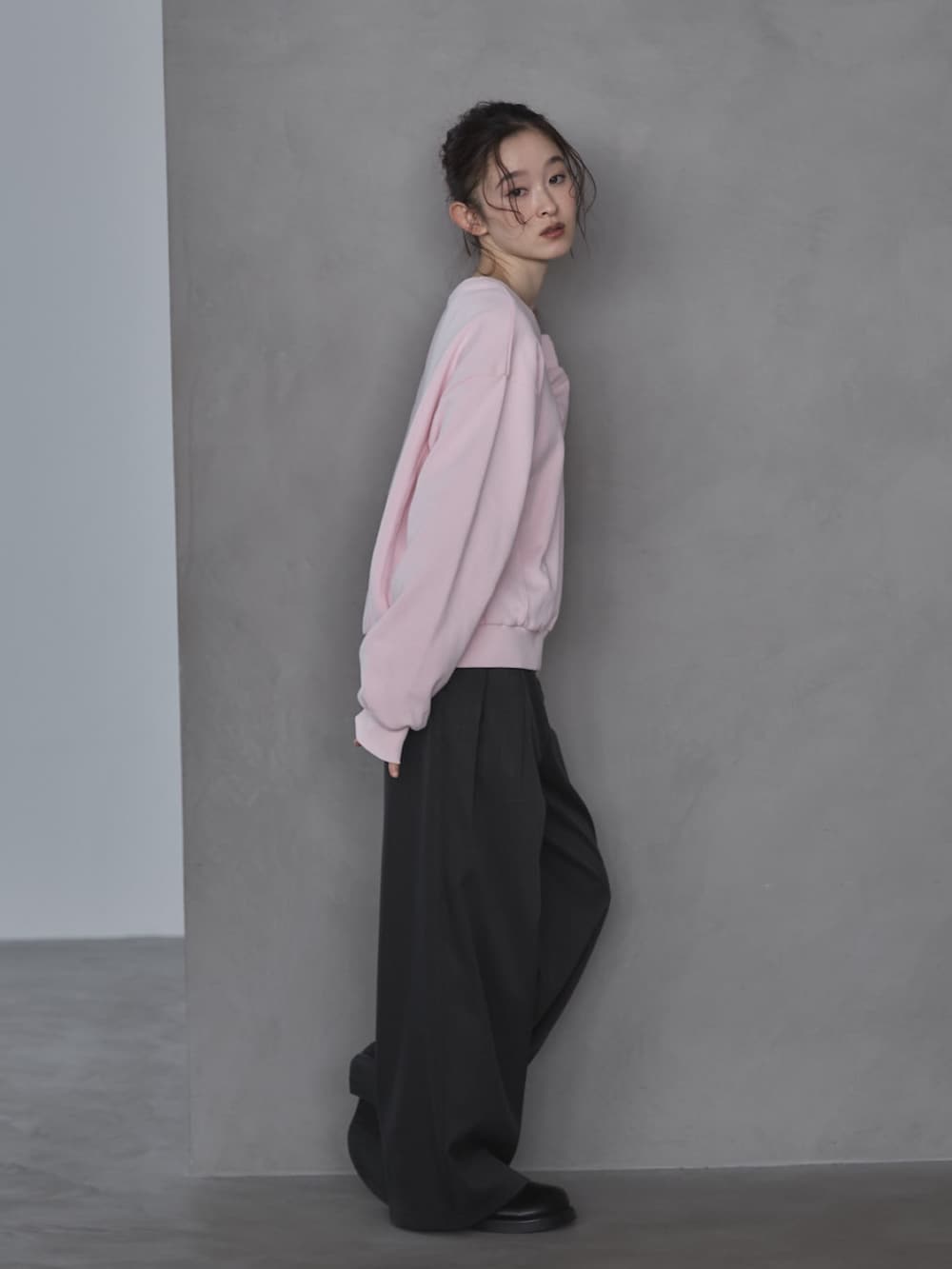 ピンク系のスウェット、グレー系のスラックス、ブラック系のその他シューズを着用したレディースの春コーディネートの3枚目の写真