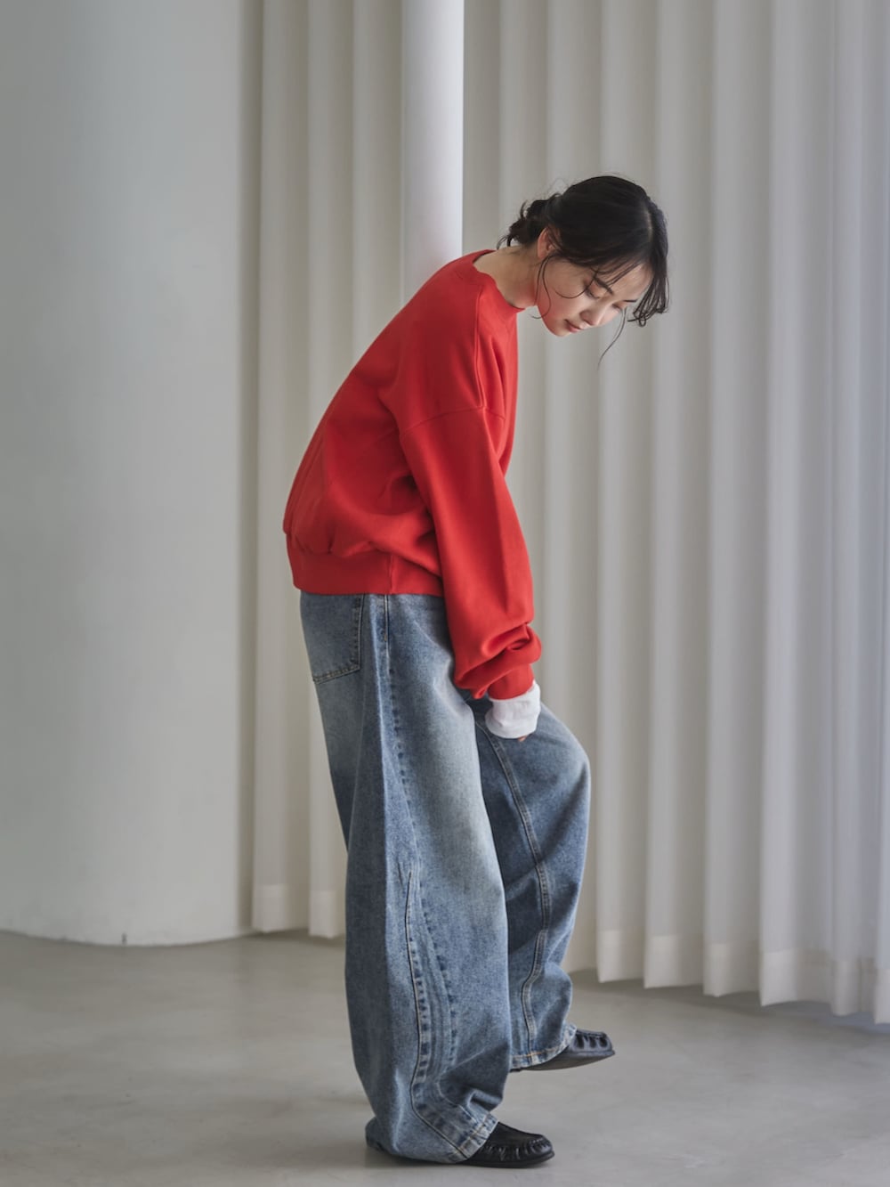 レッド系のスウェット、ホワイト系のTシャツ/カットソー、ブルー系のデニムパンツを着用したレディースの秋コーディネートの2枚目の写真