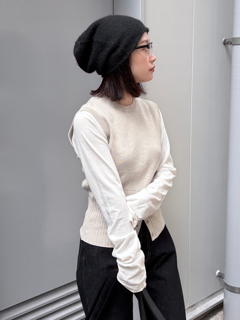 ホワイト系のTシャツ/カットソー、ホワイト系のベスト、ブラック系のデニムパンツを着用したレディースの春コーディネートの4枚目の写真