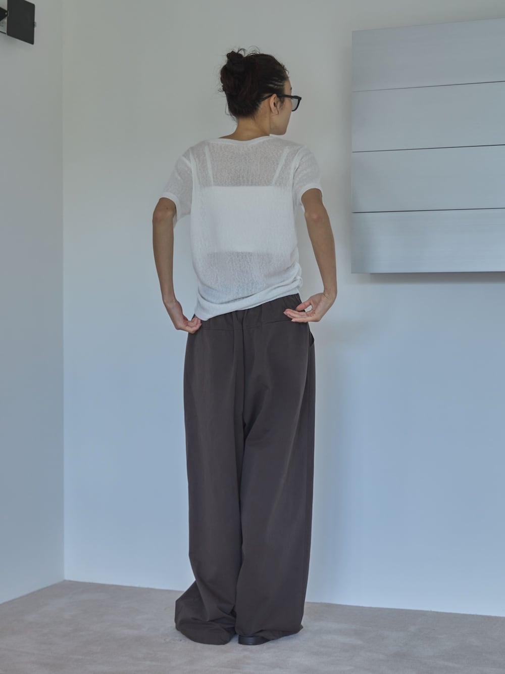 ホワイト系のTシャツ/カットソー、ブラウン系のその他パンツ、ブラック系のサンダルを着用したレディースの夏コーディネートの2枚目の写真