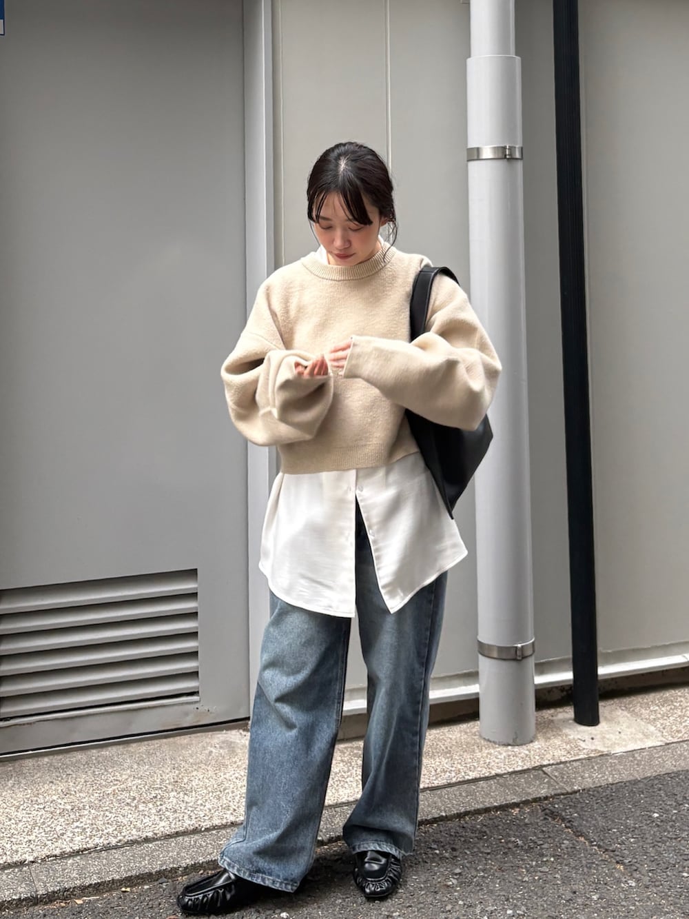 ベージュ系のニット/セーター、ホワイト系のシャツ/ブラウス、ブルー系のデニムパンツを着用したレディースの冬コーディネートの3枚目の写真