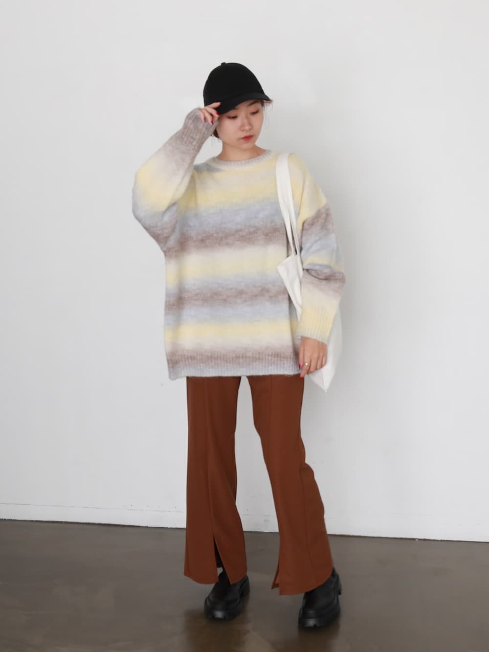 イエロー系のニット/セーター、ブラウン系のスラックス、その他のその他を着用したレディースの冬コーディネートの3枚目の写真