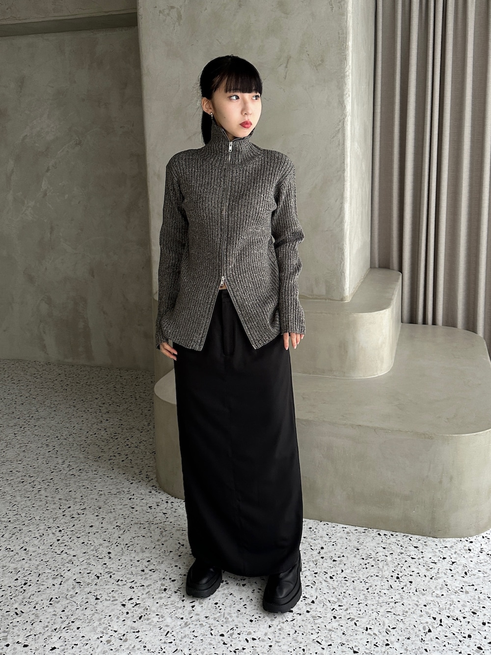 グレー系のニット/セーター、ブラック系のスカート、その他のその他を着用したレディースの秋コーディネートの2枚目の写真