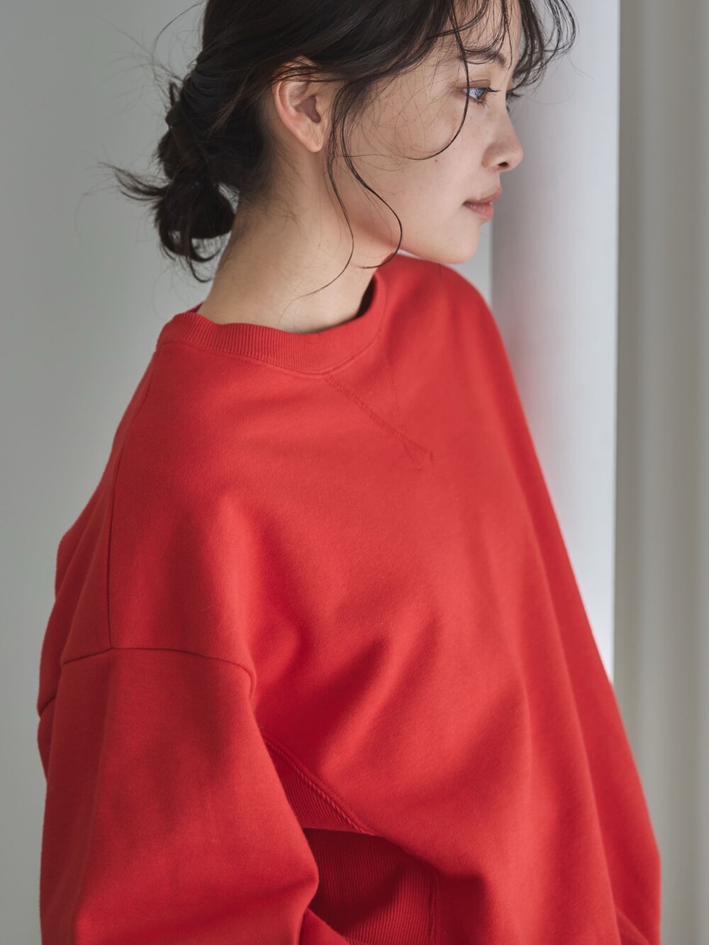 レッド系のスウェット、ホワイト系のTシャツ/カットソー、ブルー系のデニムパンツを着用したレディースの秋コーディネートの7枚目の写真
