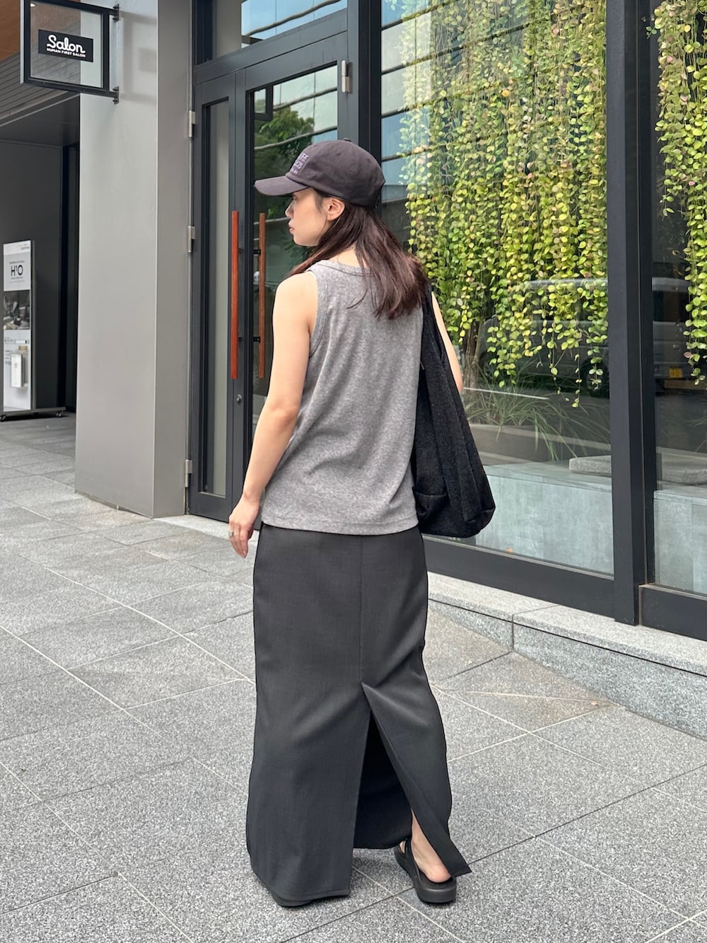 グレー系のタンクトップ、グレー系のスカート、ブラック系のトートバッグを着用したレディースの夏コーディネートの2枚目の写真