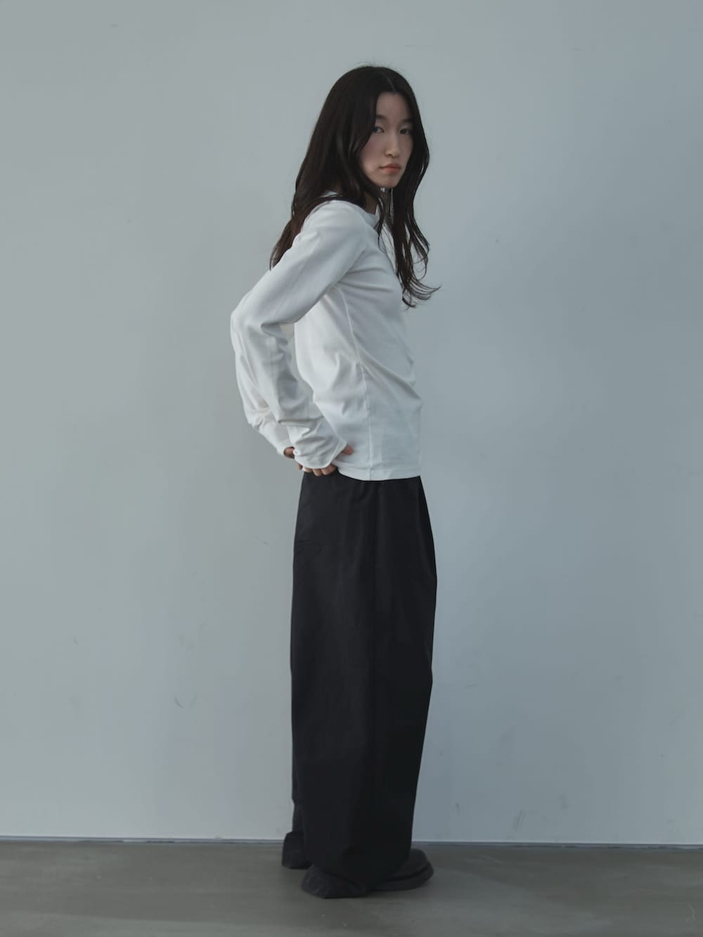 ホワイト系のTシャツ/カットソー、ブラック系のその他パンツ、ブラック系のその他シューズを着用したレディースの春コーディネートの2枚目の写真