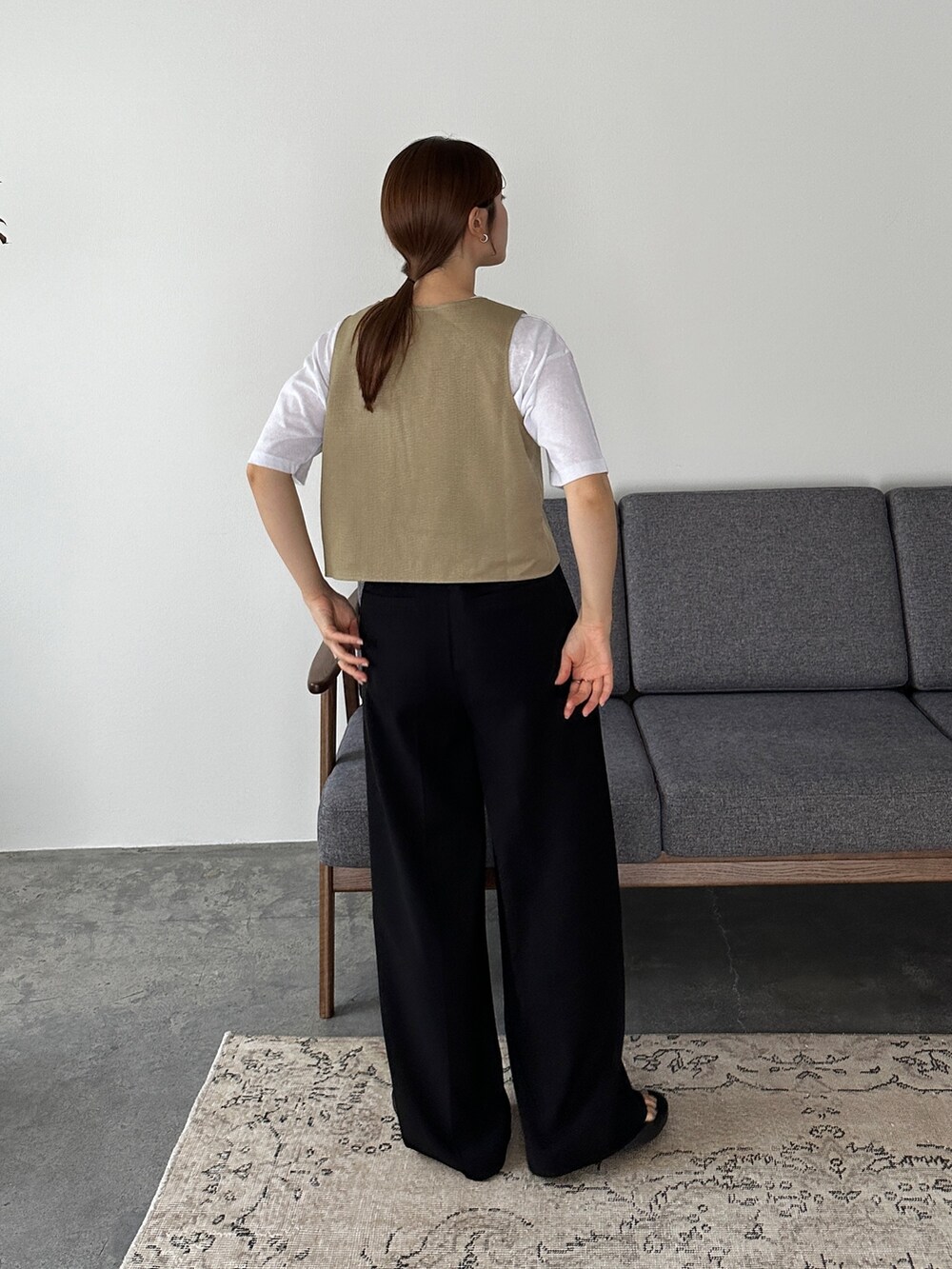 ベージュ系のベスト、ホワイト系のTシャツ/カットソー、ブラック系のサンダルを着用したレディースの夏コーディネートの2枚目の写真