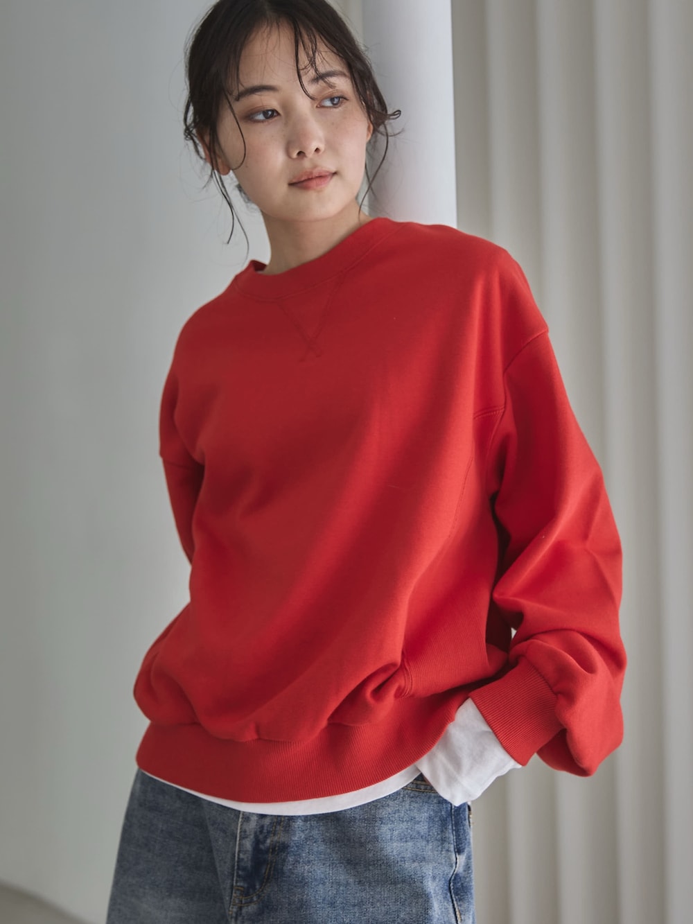 レッド系のスウェット、ホワイト系のTシャツ/カットソー、ブルー系のデニムパンツを着用したレディースの秋コーディネートの5枚目の写真