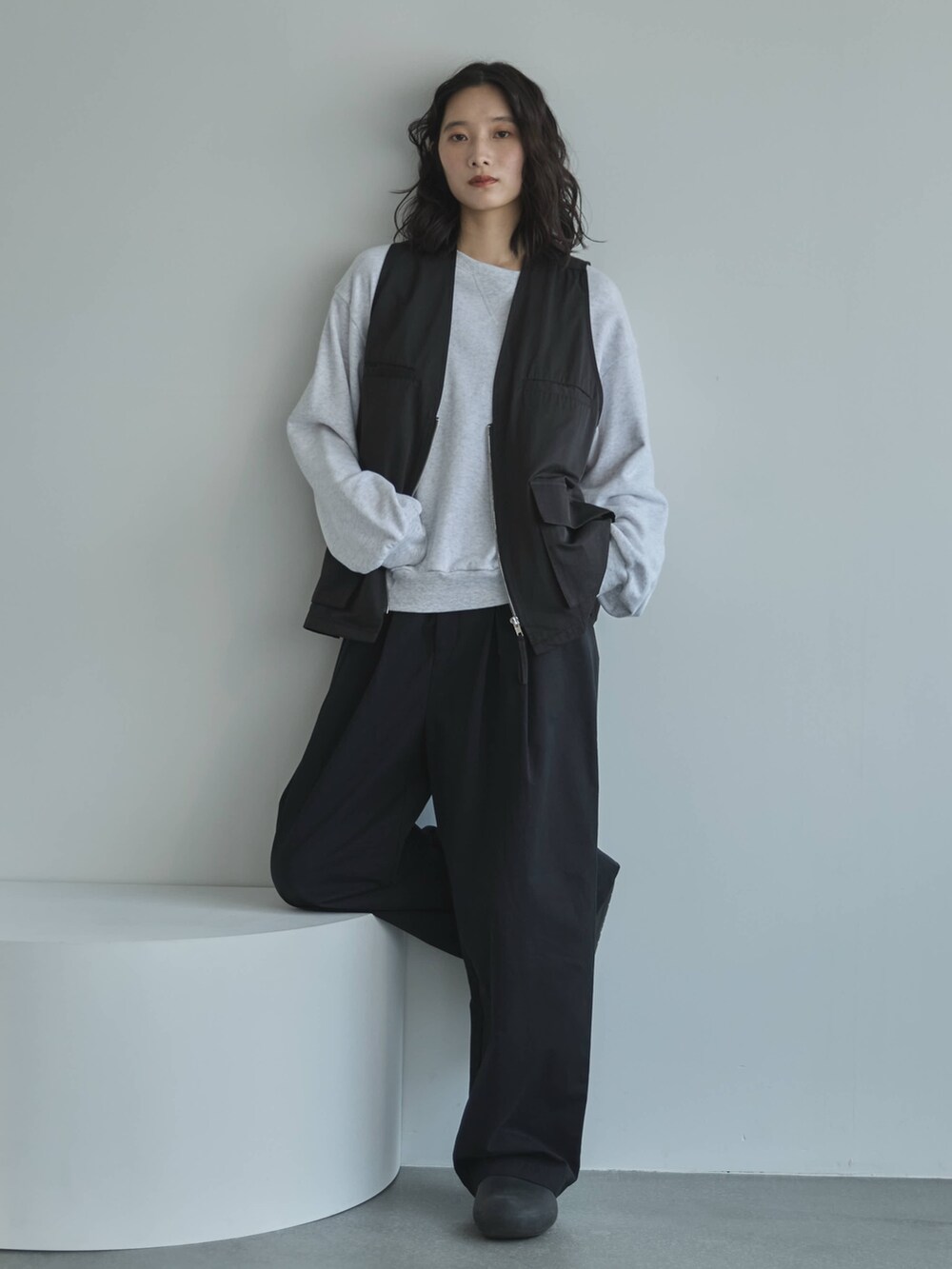 ブラック系のその他パンツ、ブラック系のベスト、ベージュ系のスウェットを着用したレディースの秋コーディネートの4枚目の写真