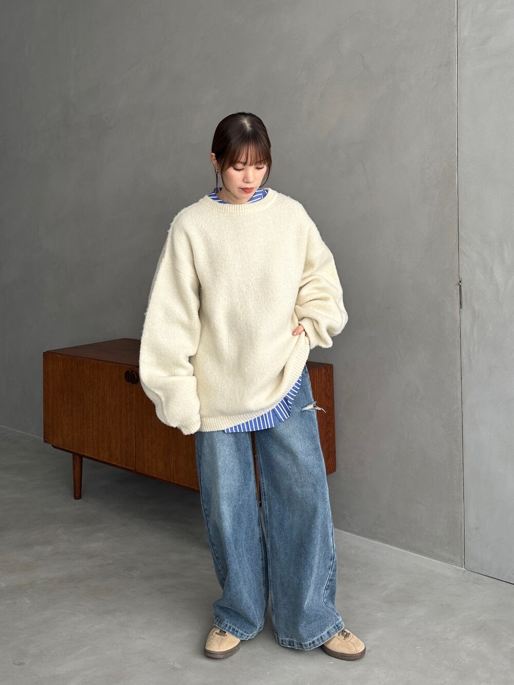 ホワイト系のニット/セーター、ブルー系のシャツ/ブラウス、ブルー系のデニムパンツを着用したレディースの冬コーディネートの3枚目の写真