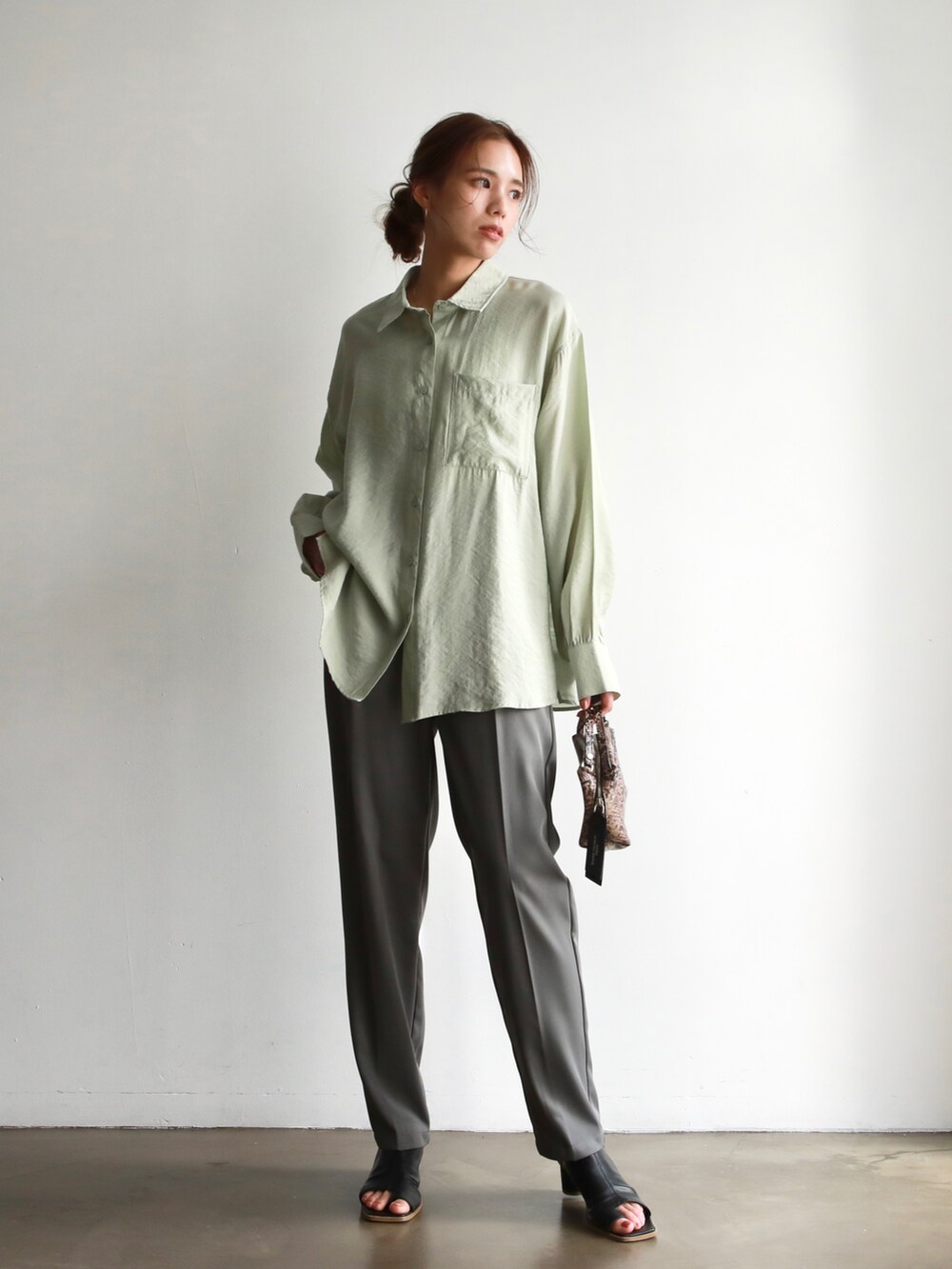 ホワイト系のシャツ/ブラウス、ブラック系のハンドバッグ、ブラウン系のサンダルを着用したレディースの春コーディネートの4枚目の写真