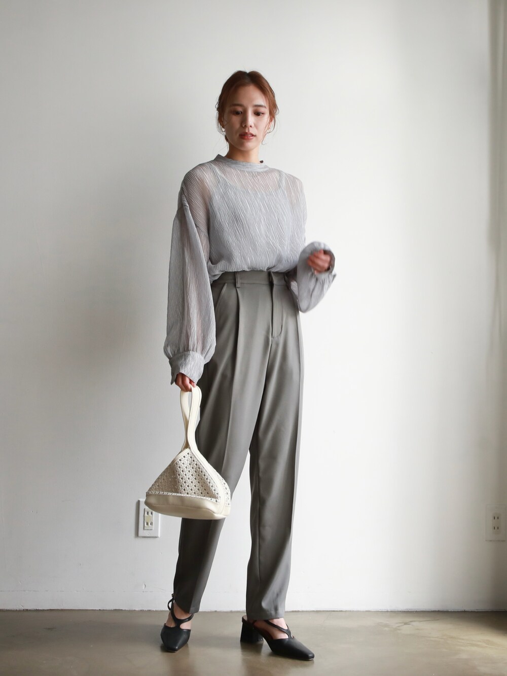 ホワイト系のシャツ/ブラウス、ブラック系のハンドバッグ、ブラウン系のサンダルを着用したレディースの春コーディネートの2枚目の写真