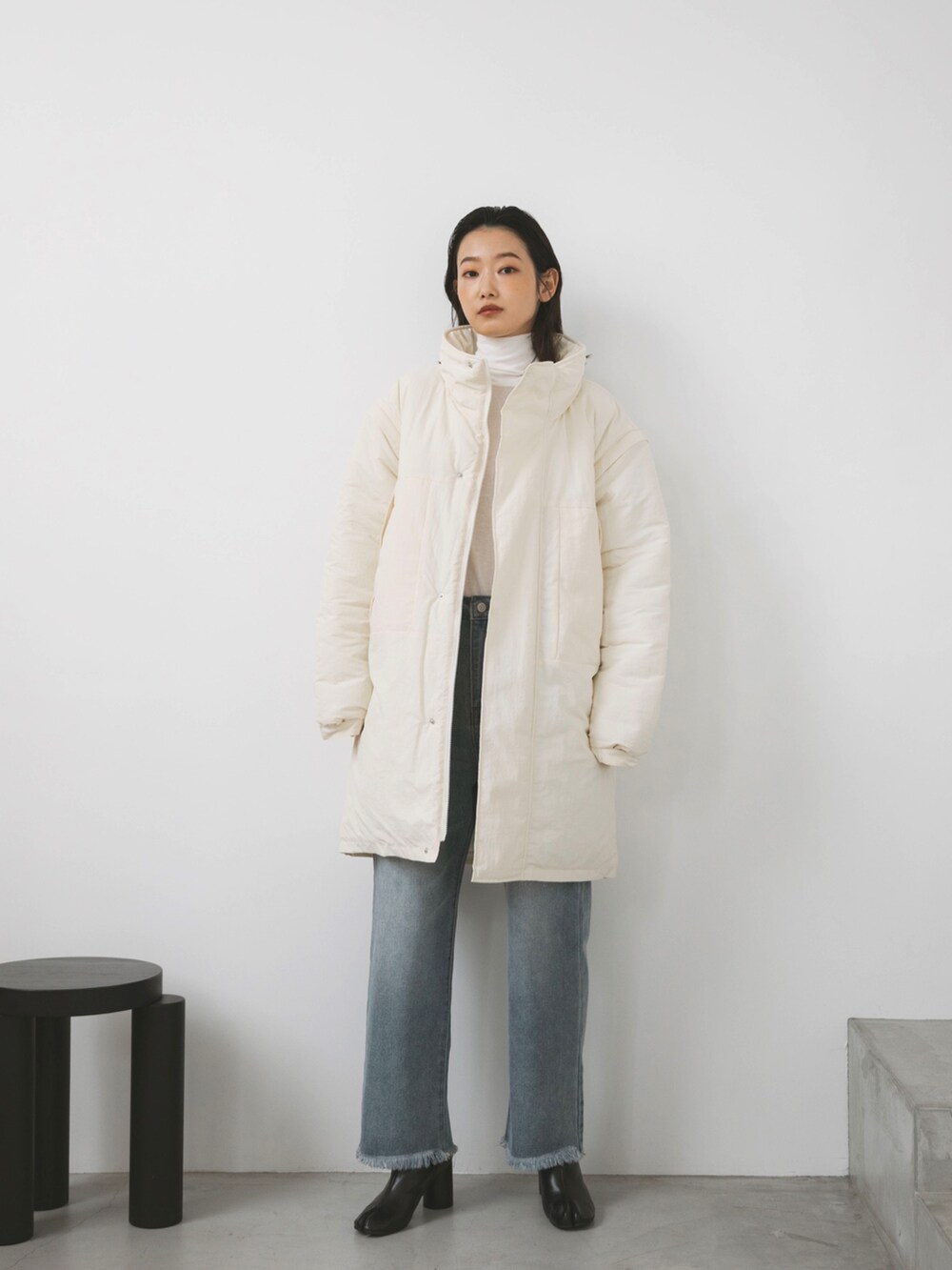 ホワイト系のダウンジャケット/コート、ホワイト系のTシャツ/カットソー、ブルー系のデニムパンツを着用したレディースの秋コーディネートの2枚目の写真