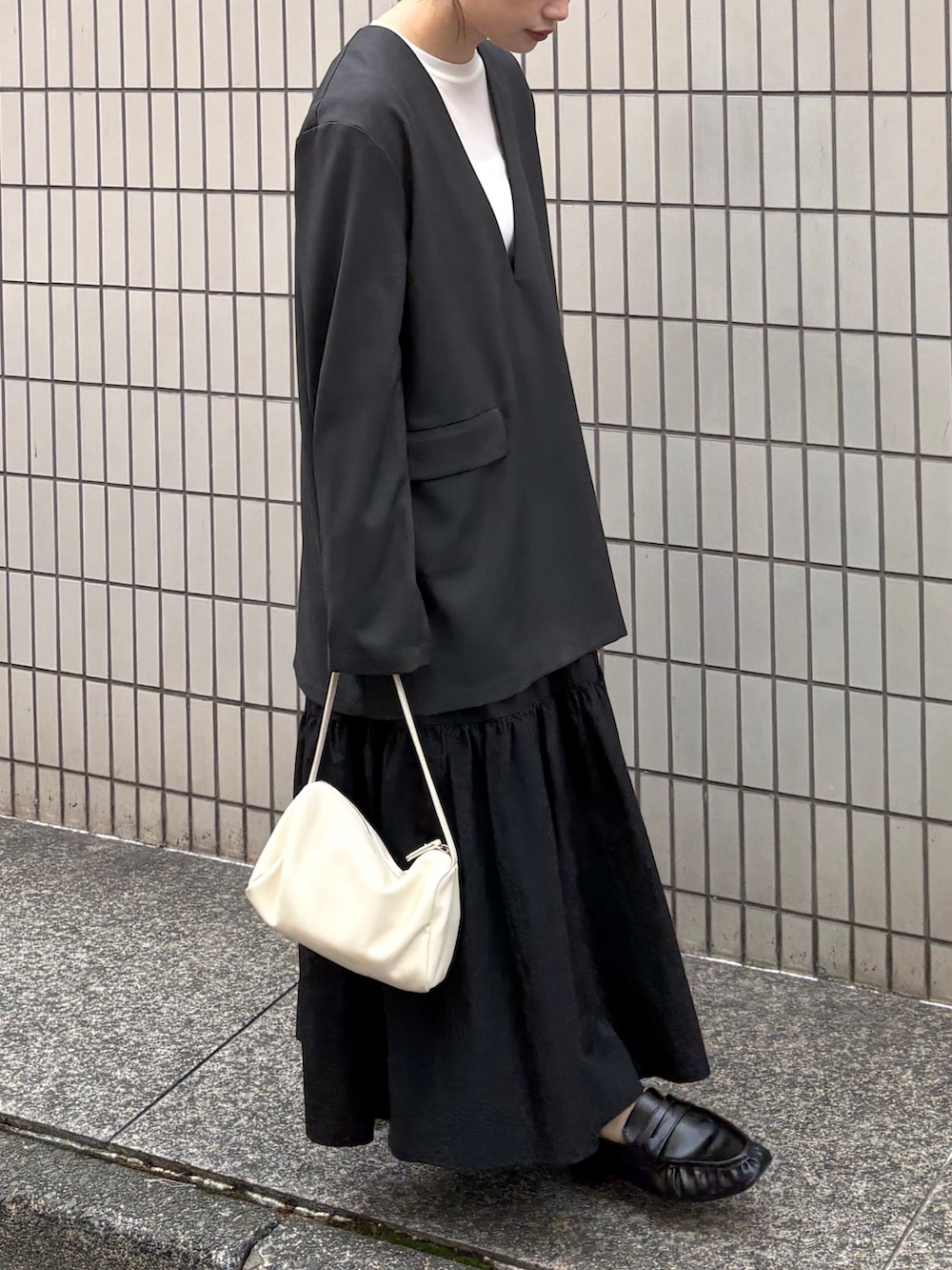 グレー系のその他トップス、ホワイト系のTシャツ/カットソー、ブラック系のスカートを着用したレディースの春コーディネートの4枚目の写真