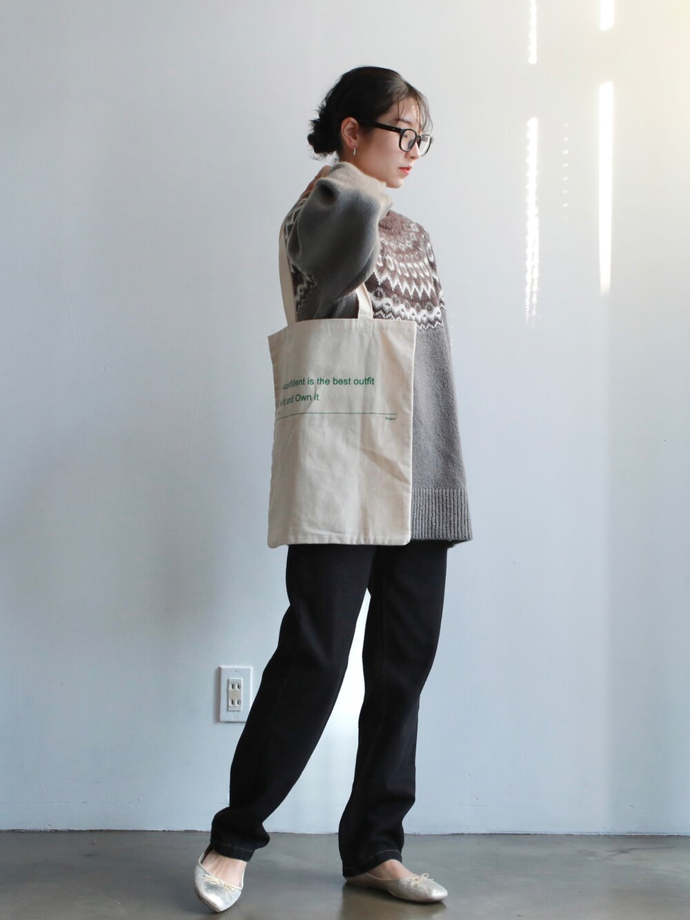 グレー系のニット/セーター、ホワイト系のトートバッグ、ゴールド系のバレエシューズを着用したレディースの冬コーディネートの2枚目の写真