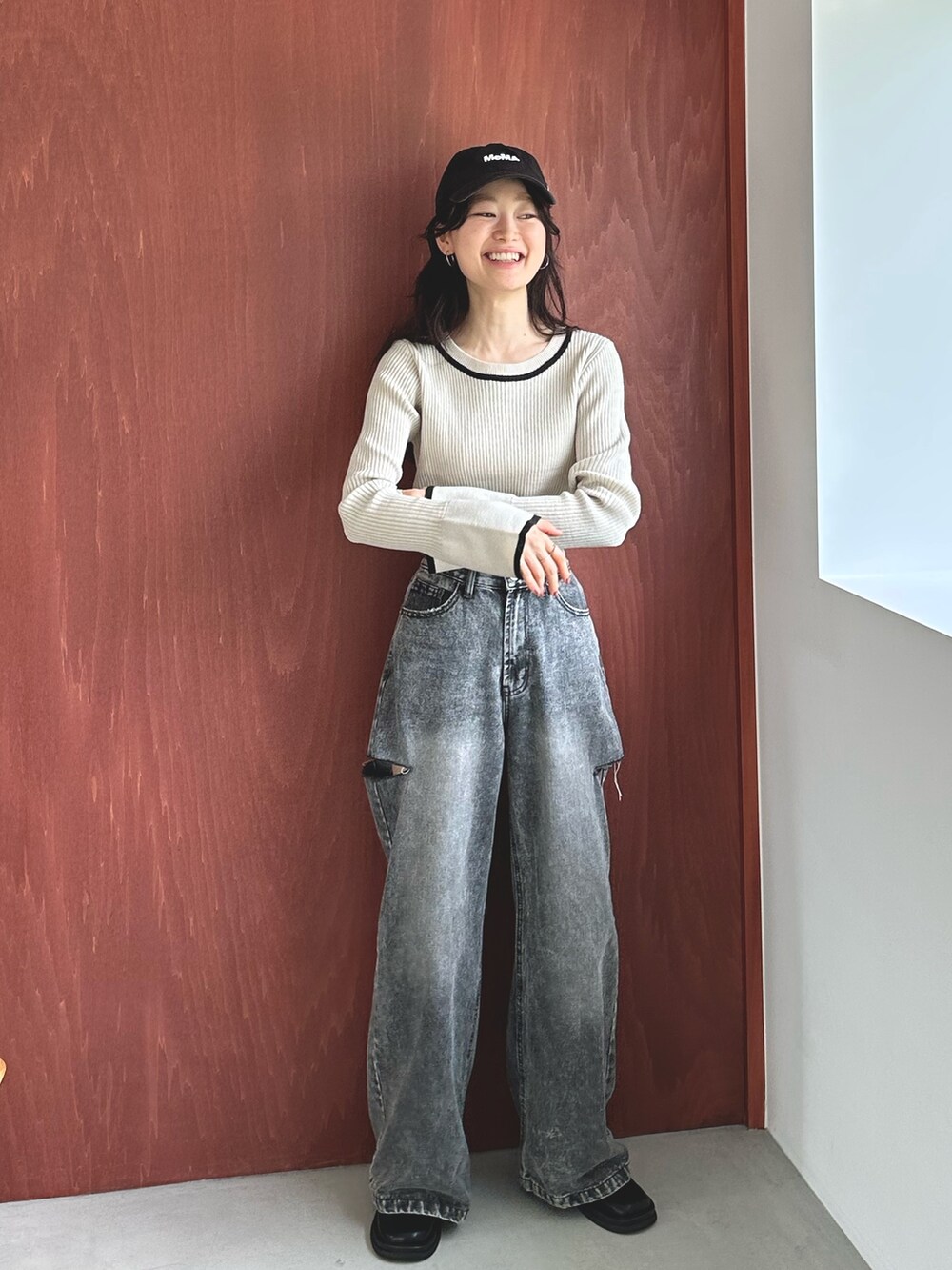 ブラック系のデニムパンツ、ブラック系のスリッポン、ホワイト系のニット/セーターを着用したレディースの秋コーディネートの4枚目の写真