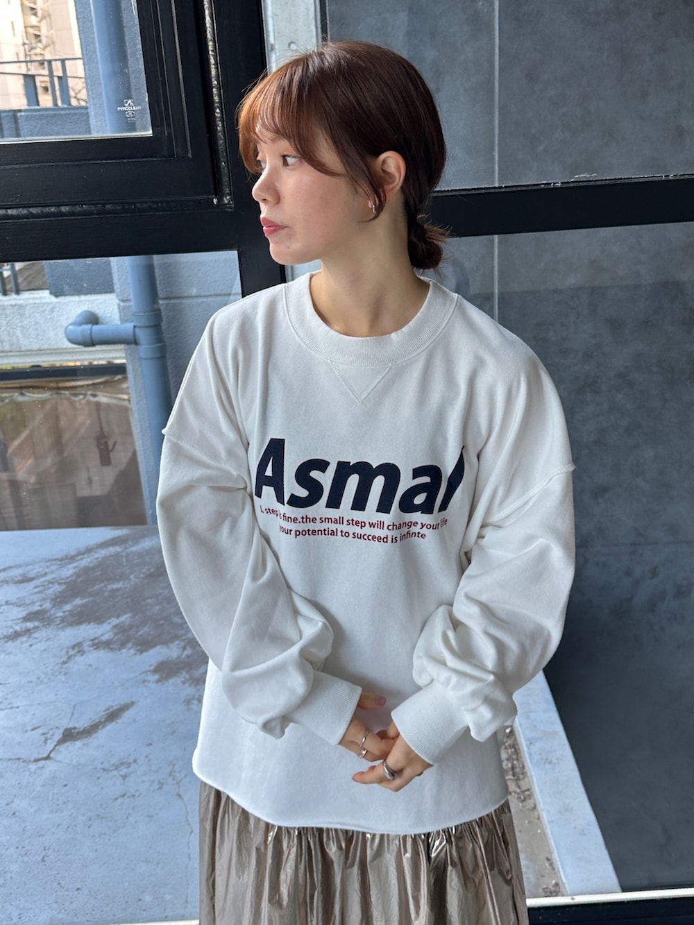 ブラック系のスニーカー、ホワイト系のスウェット、ゴールド系のスカートを着用したレディースの冬コーディネートの3枚目の写真