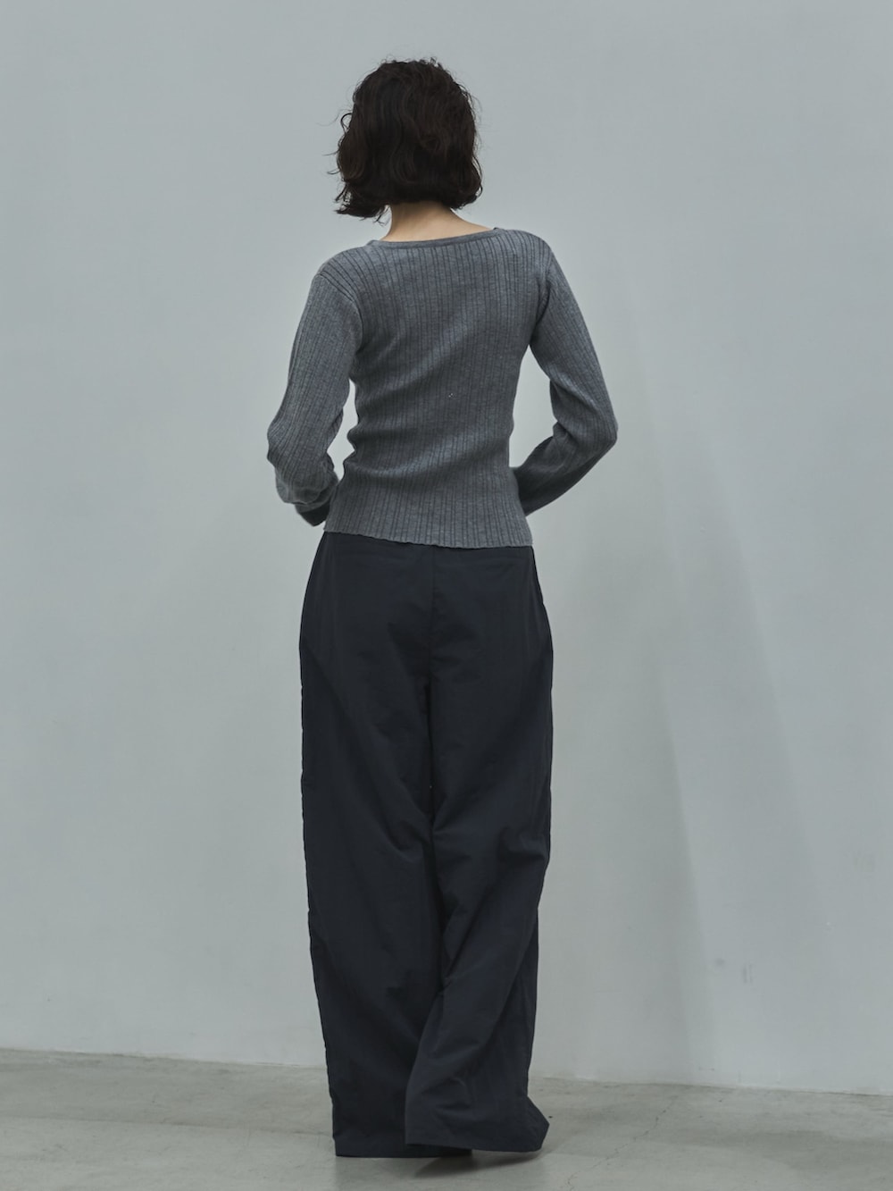 グレー系のニット/セーター、ブルー系のその他パンツ、ブラック系のローファーを着用したレディースの秋コーディネートの3枚目の写真