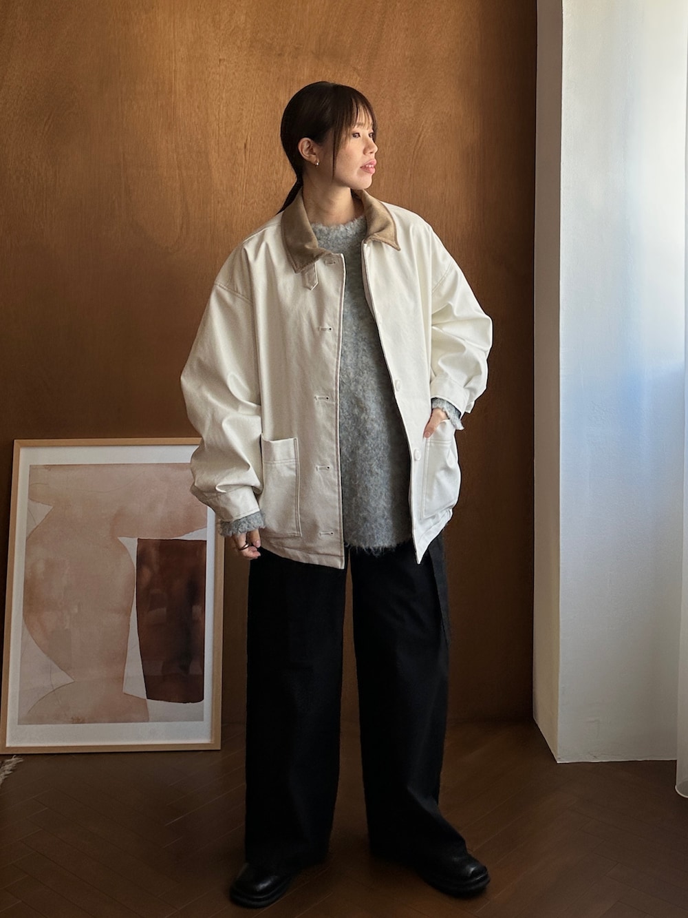 ホワイト系のブルゾン、グレー系のニット/セーター、ブラック系のサロペット/オーバーオールを着用したレディースの冬コーディネートの2枚目の写真