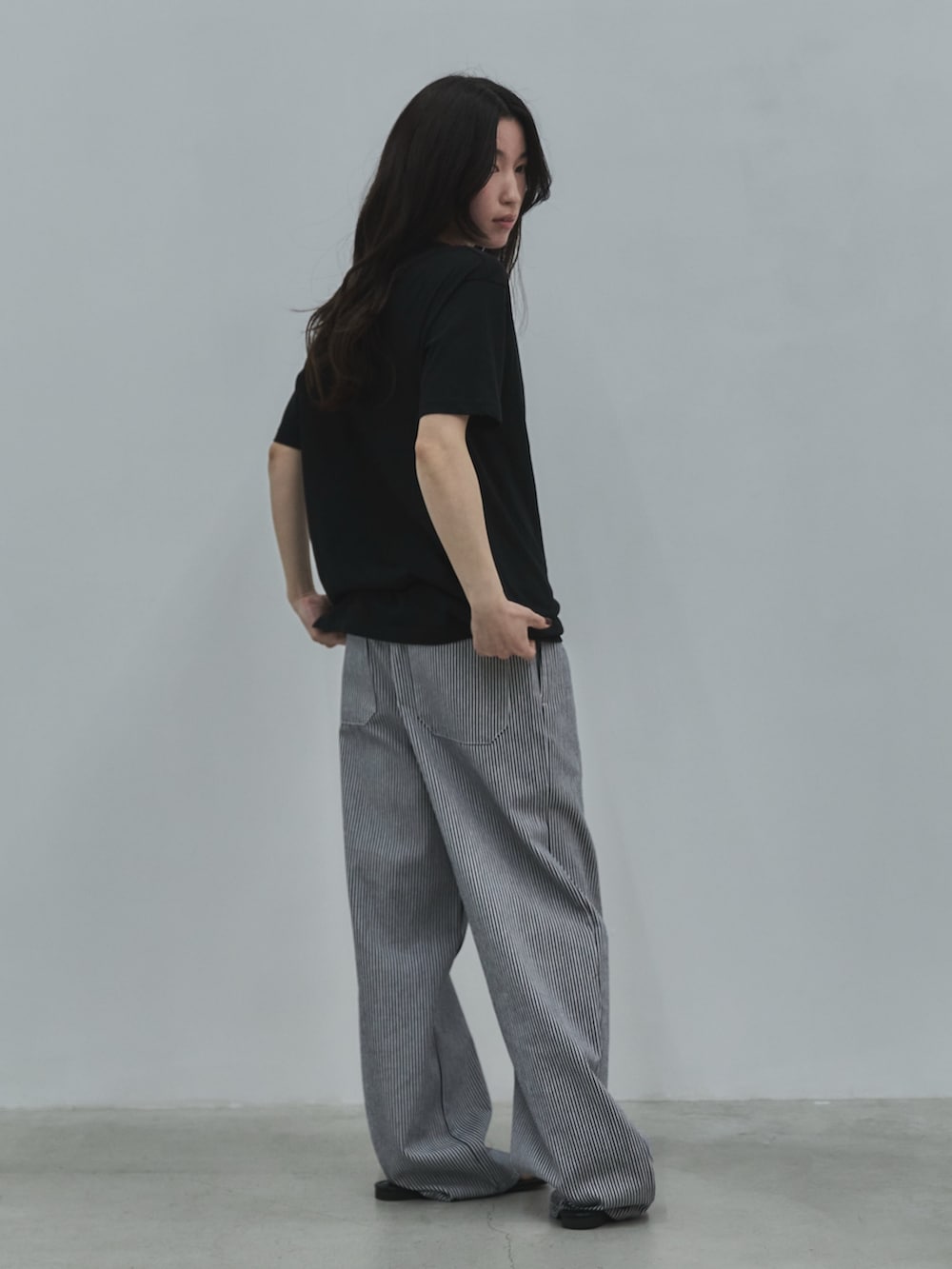 ブラック系のTシャツ/カットソー、ブラック系のデニムパンツ、ブラック系のサンダルを着用したレディースの春コーディネートの3枚目の写真