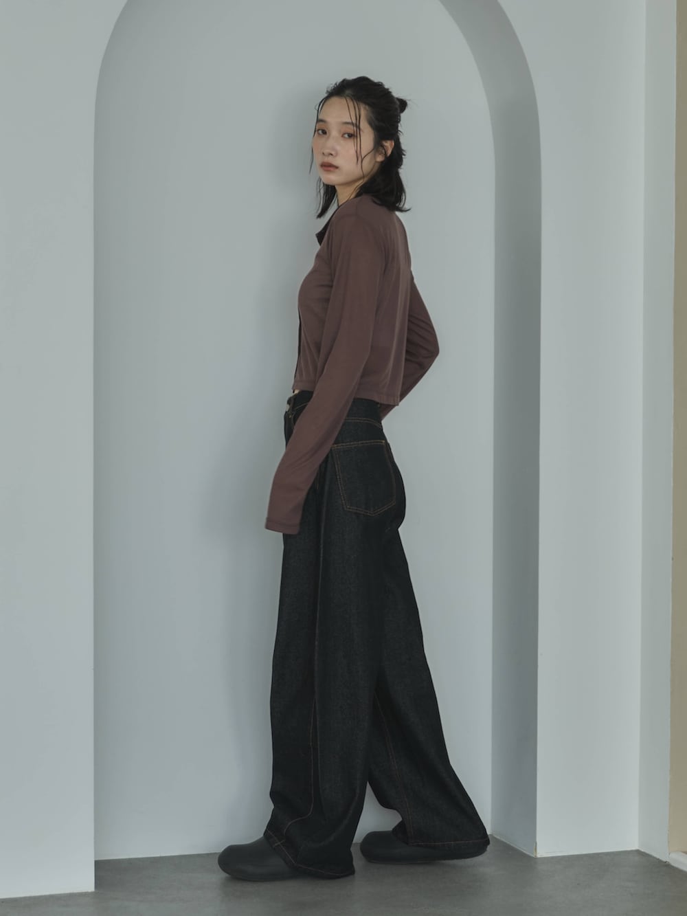 ブラウン系のカーディガン/ボレロ、ホワイト系のキャミソール、ブラック系のデニムパンツを着用したレディースの春コーディネートの3枚目の写真