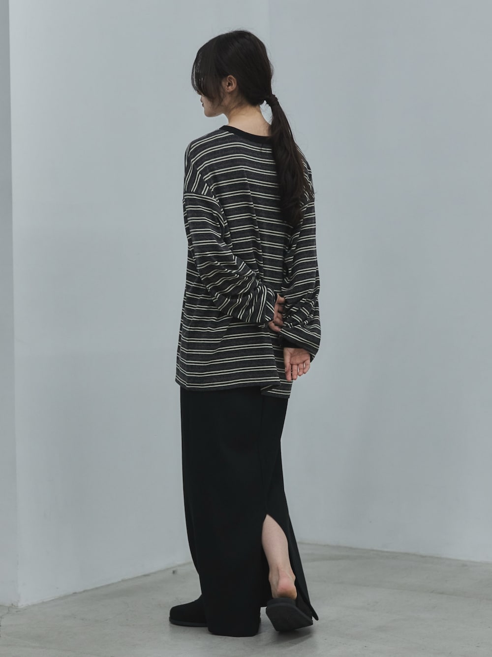 グレー系のTシャツ/カットソー、ブラック系のスカート、ブラック系のその他シューズを着用したレディースの秋コーディネートの3枚目の写真