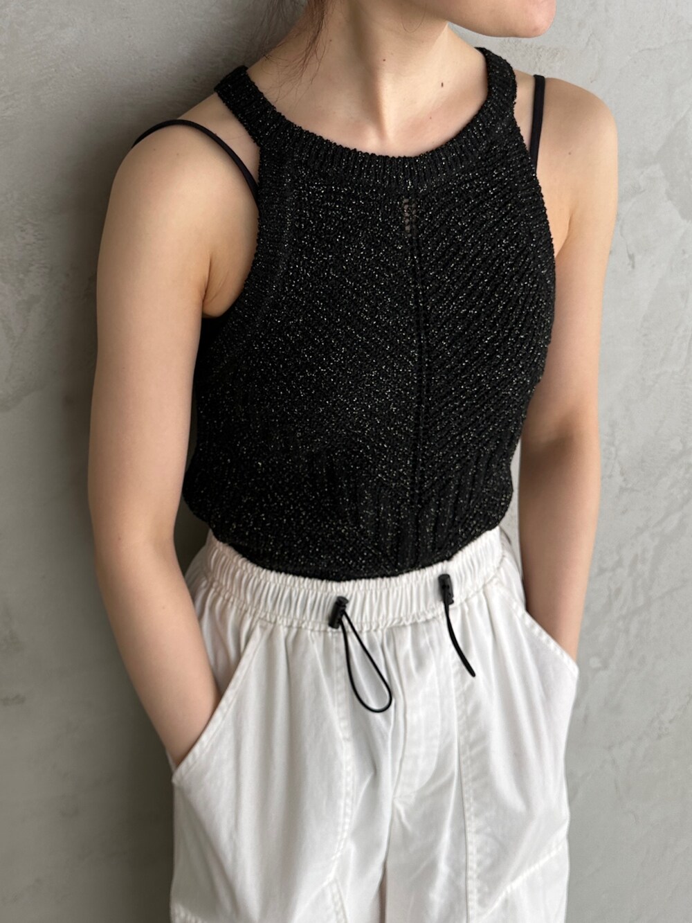 ブラック系のニット/セーター、ホワイト系のカーゴパンツ、ホワイト系のスニーカーを着用したレディースの春コーディネートの3枚目の写真