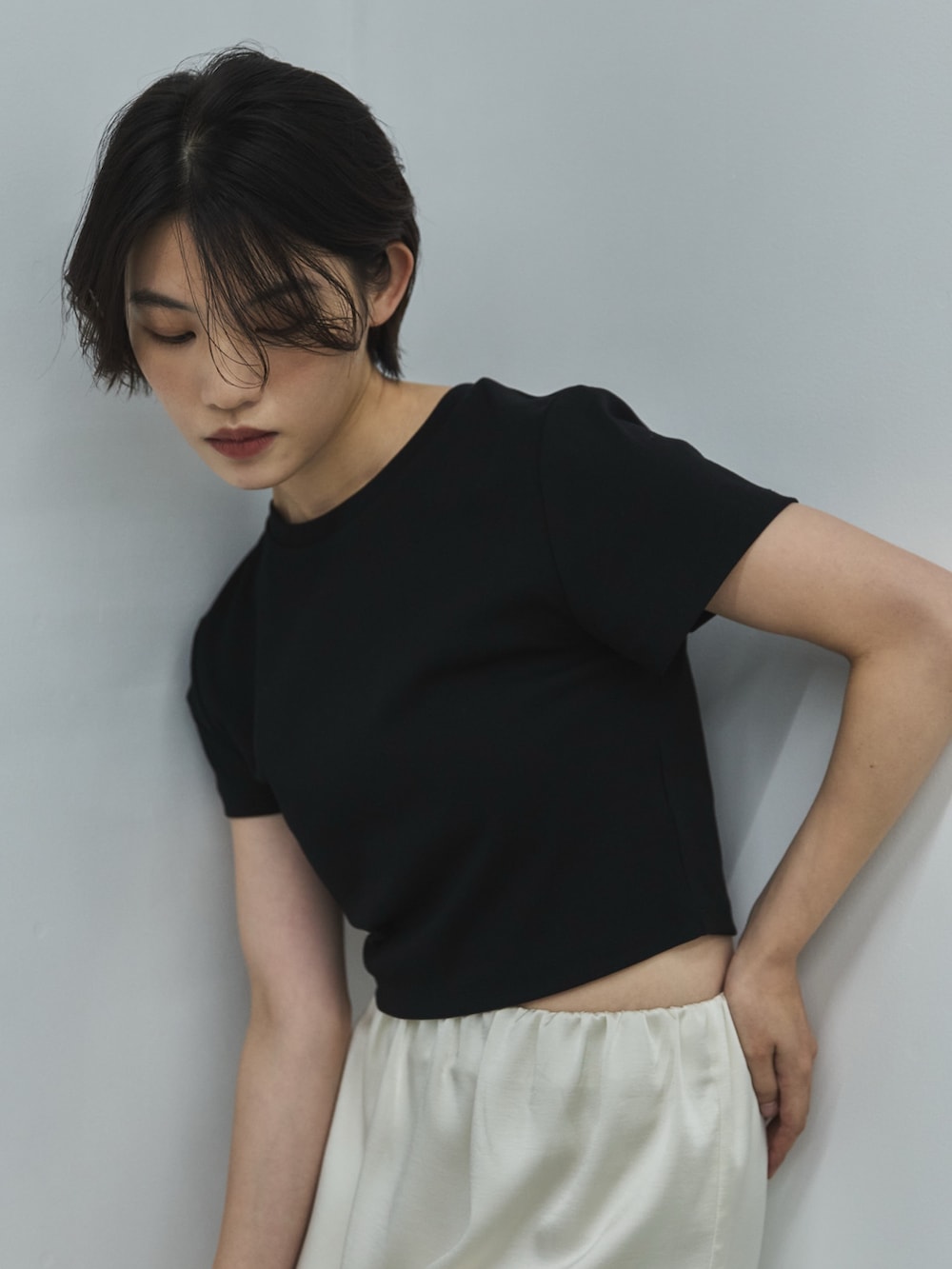 ブラック系のTシャツ/カットソー、ホワイト系のスカート、ブラック系のサンダルを着用したレディースの夏コーディネートの5枚目の写真
