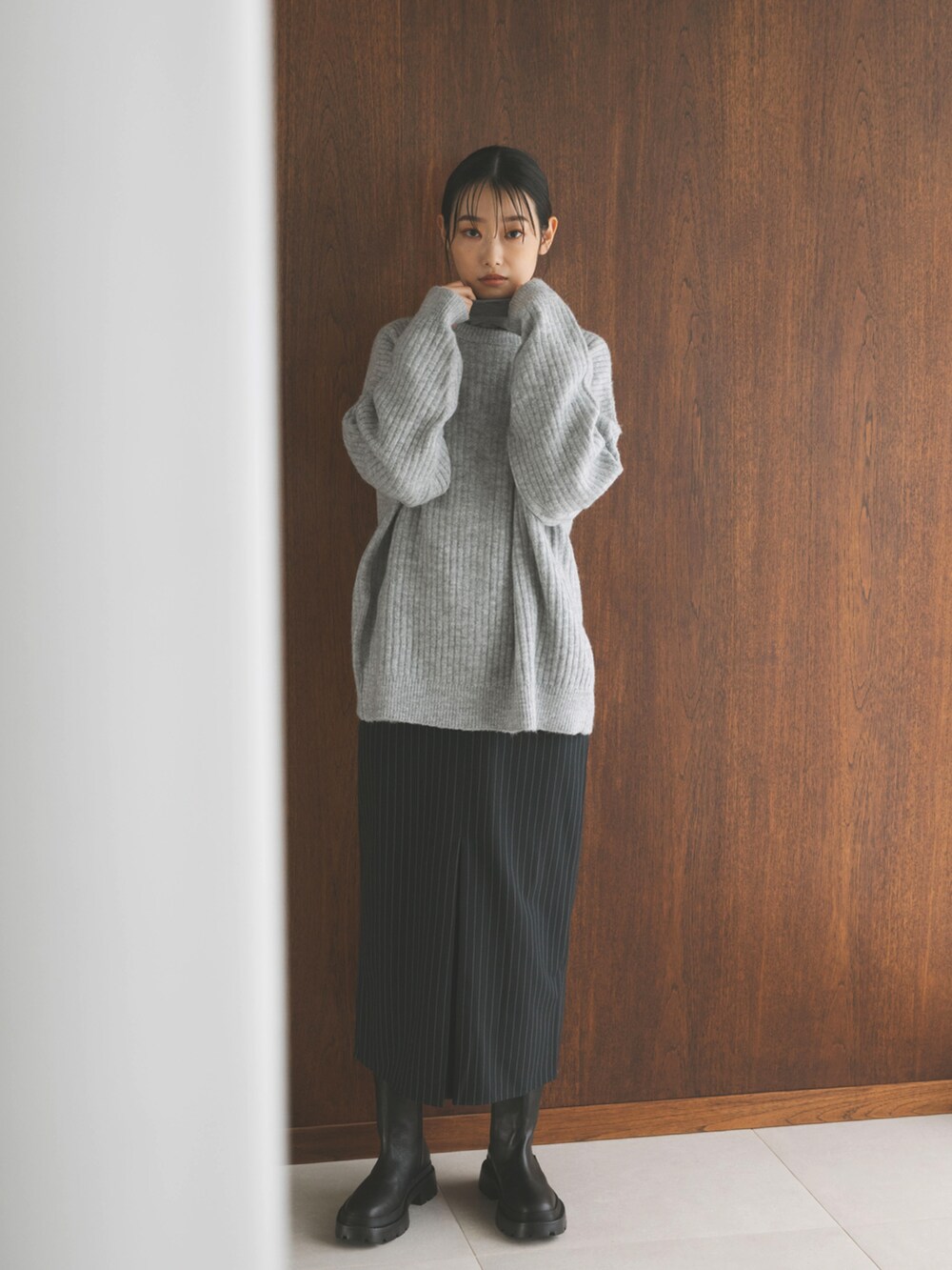 ブルー系のスカート、グレー系のカーディガン/ボレロ、グレー系のTシャツ/カットソーを着用したレディースの秋コーディネートの3枚目の写真