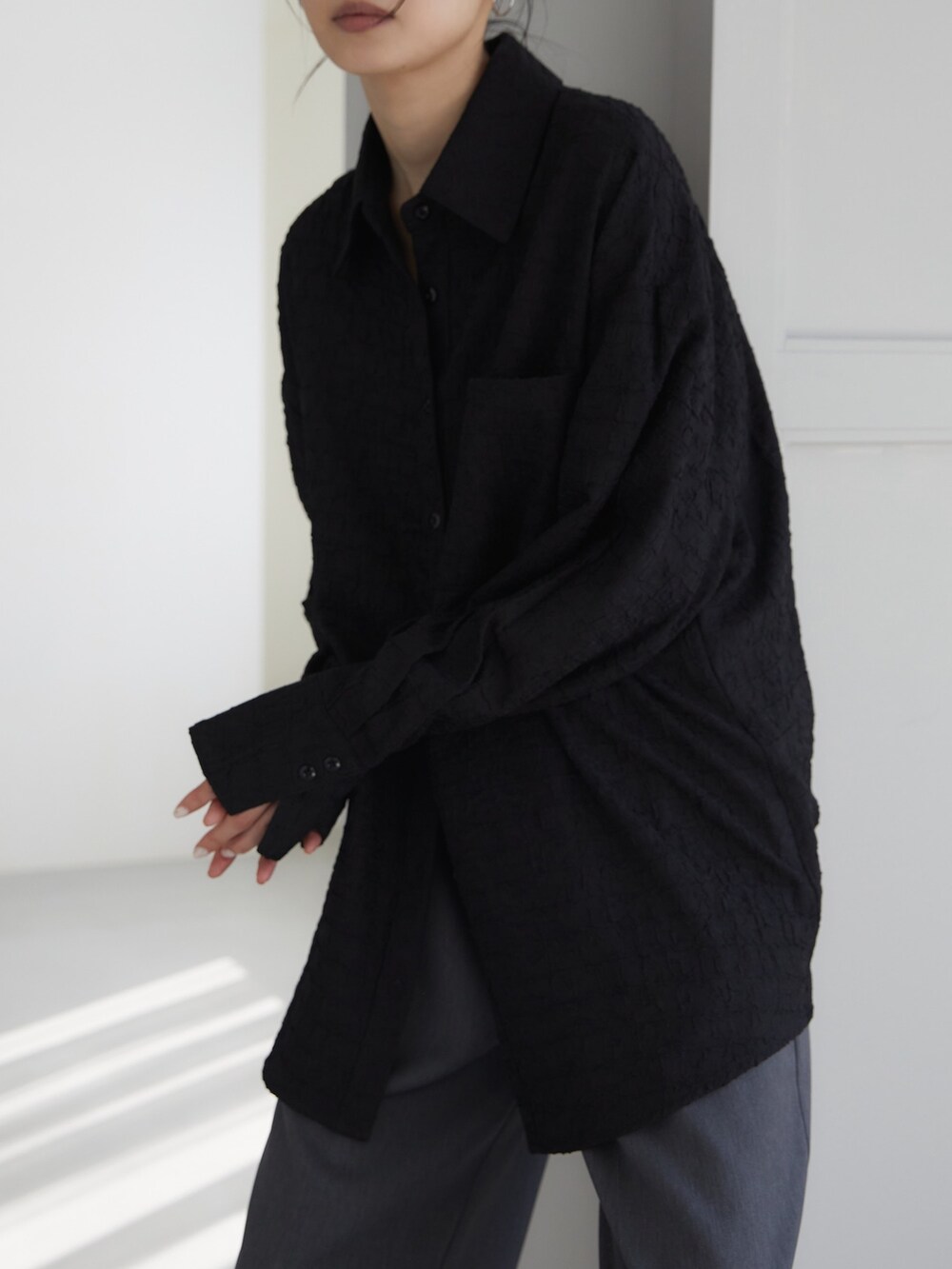 ブラック系のシャツ/ブラウス、グレー系のスラックス、ブラック系のサンダルを着用したレディースの夏コーディネートの4枚目の写真