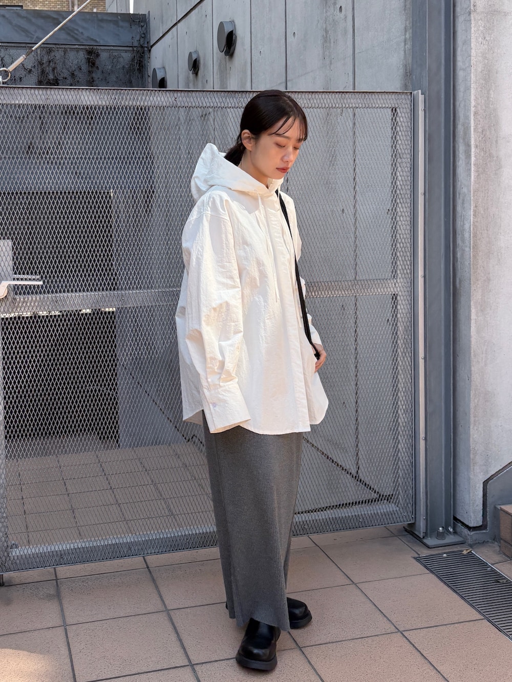 ブラック系のショルダーバッグ、ホワイト系のシャツ/ブラウス、グレー系のスカートを着用したレディースの春コーディネートの3枚目の写真