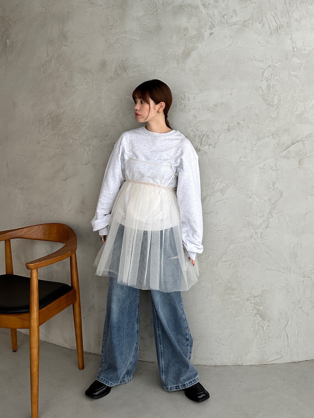 ベージュ系のスウェット、ホワイト系のシャツ/ブラウス、ブルー系のデニムパンツを着用したレディースの冬コーディネートの3枚目の写真