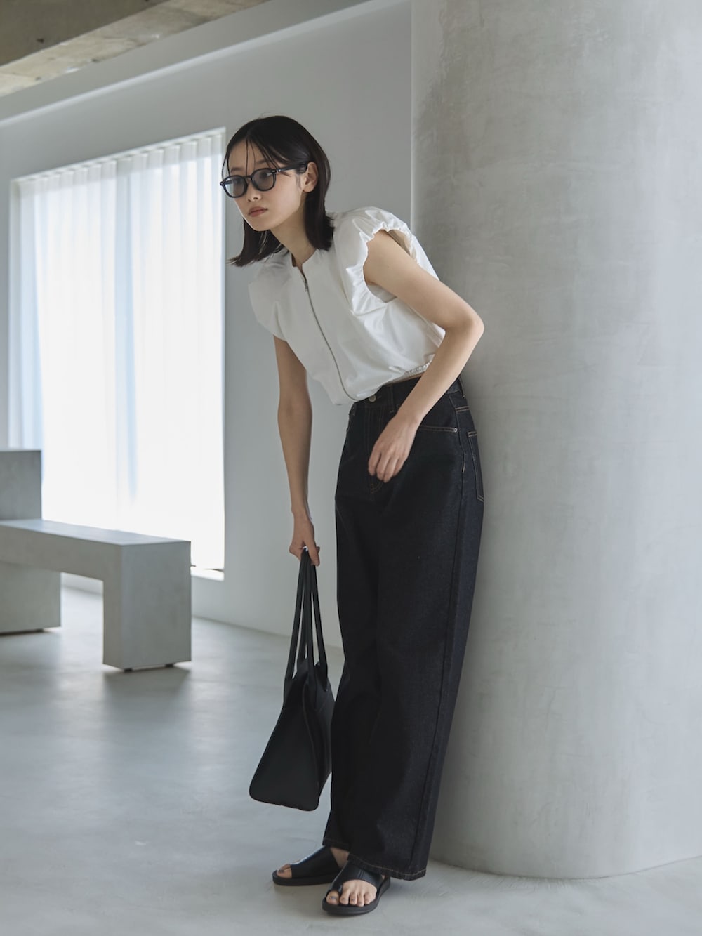 ブラック系のデニムパンツ、ホワイト系のシャツ/ブラウス、ブラック系のボストンバッグを着用したレディースの夏コーディネートの3枚目の写真