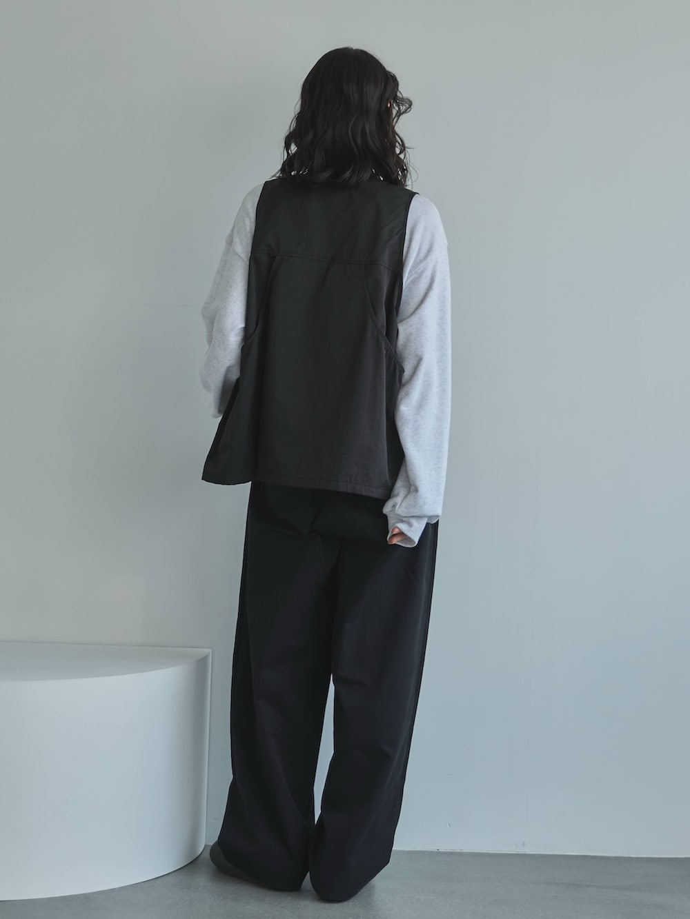 ブラック系のその他パンツ、ブラック系のベスト、ベージュ系のスウェットを着用したレディースの秋コーディネートの3枚目の写真