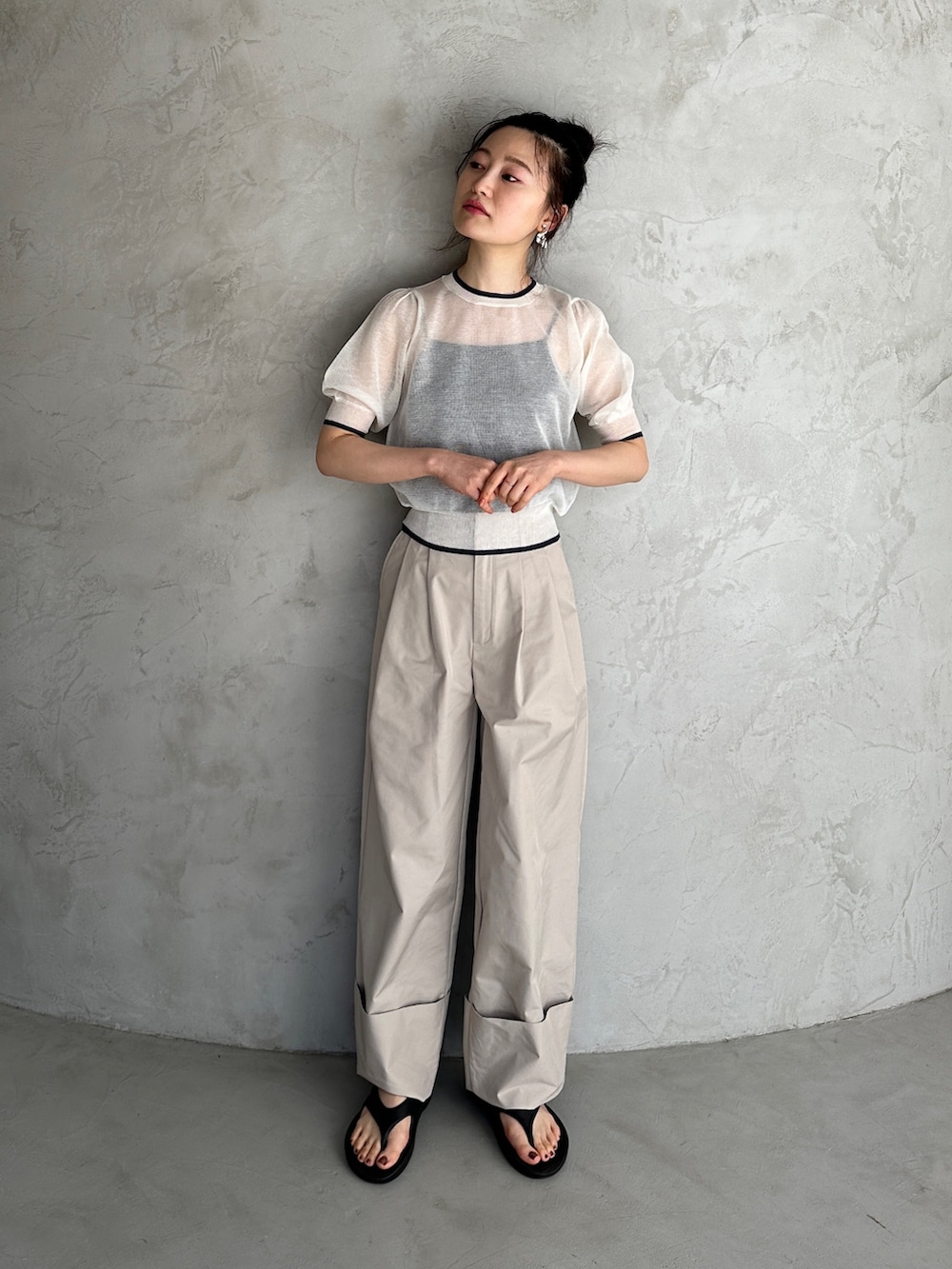 ホワイト系のニット/セーター、ベージュ系のその他パンツ、ブラック系のサンダルを着用したレディースの春コーディネートの2枚目の写真