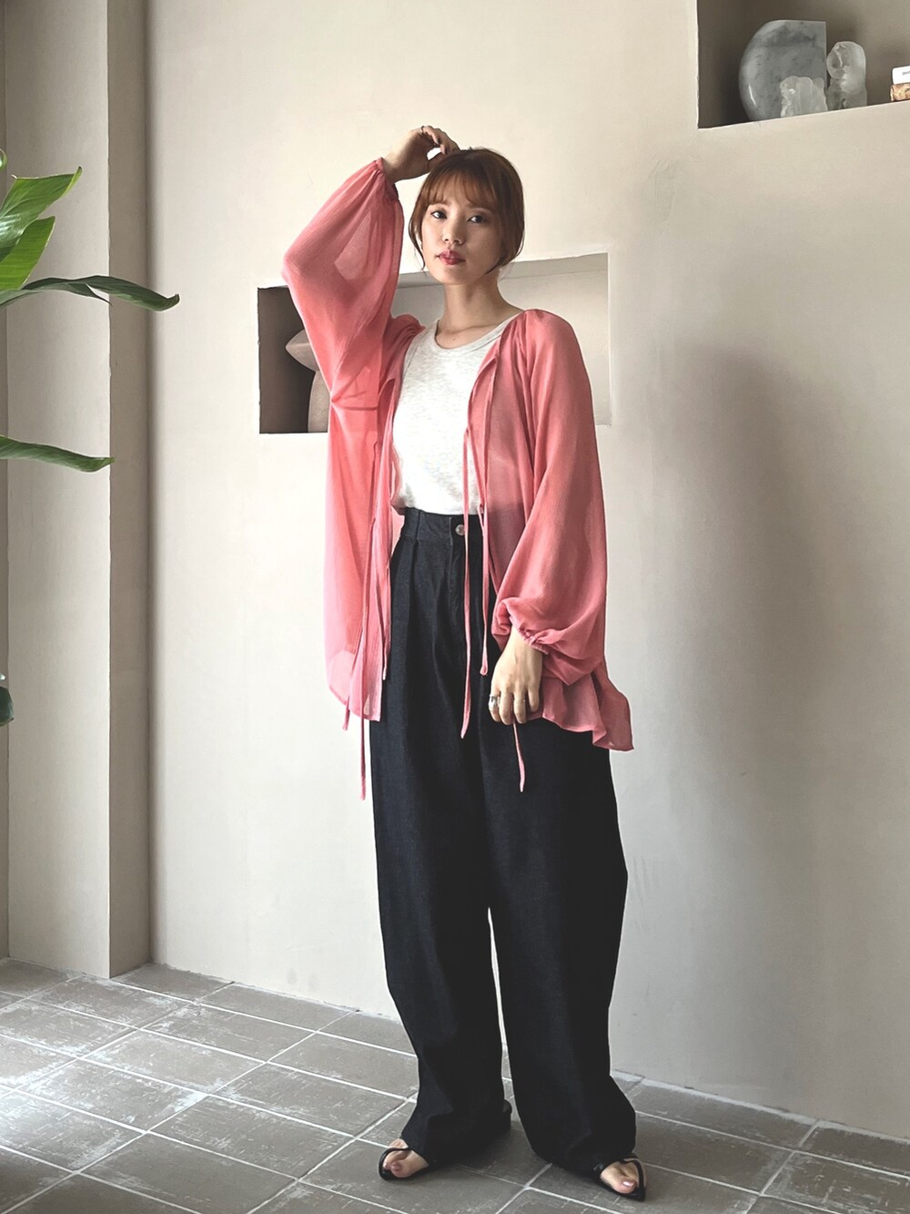 ブラック系のデニムパンツ、ブラック系のサンダル、ベージュ系のタンクトップを着用したレディースの春コーディネートの3枚目の写真