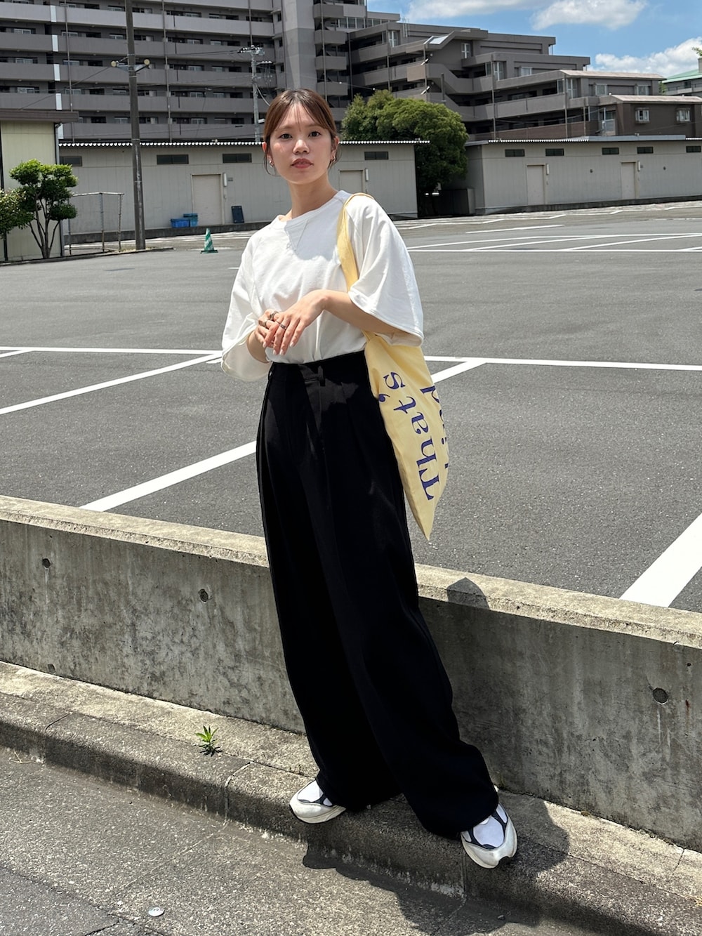 ホワイト系のTシャツ/カットソー、イエロー系のトートバッグ、ホワイト系のスニーカーを着用したレディースの夏コーディネートの2枚目の写真