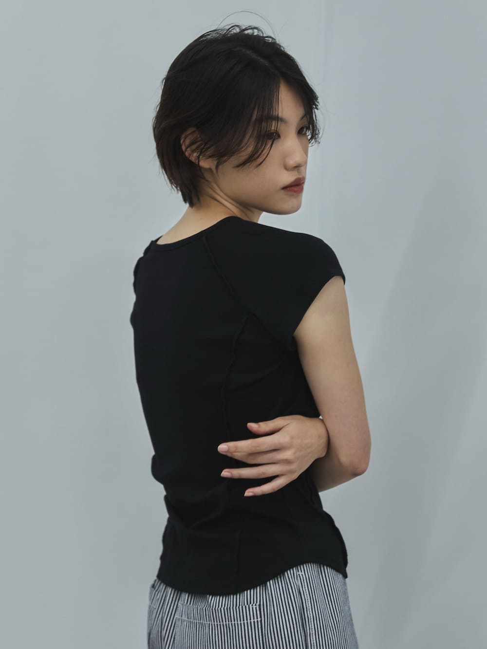 ブラック系のTシャツ/カットソー、ホワイト系のデニムパンツ、ブラック系のサンダルを着用したレディースの夏コーディネートの4枚目の写真