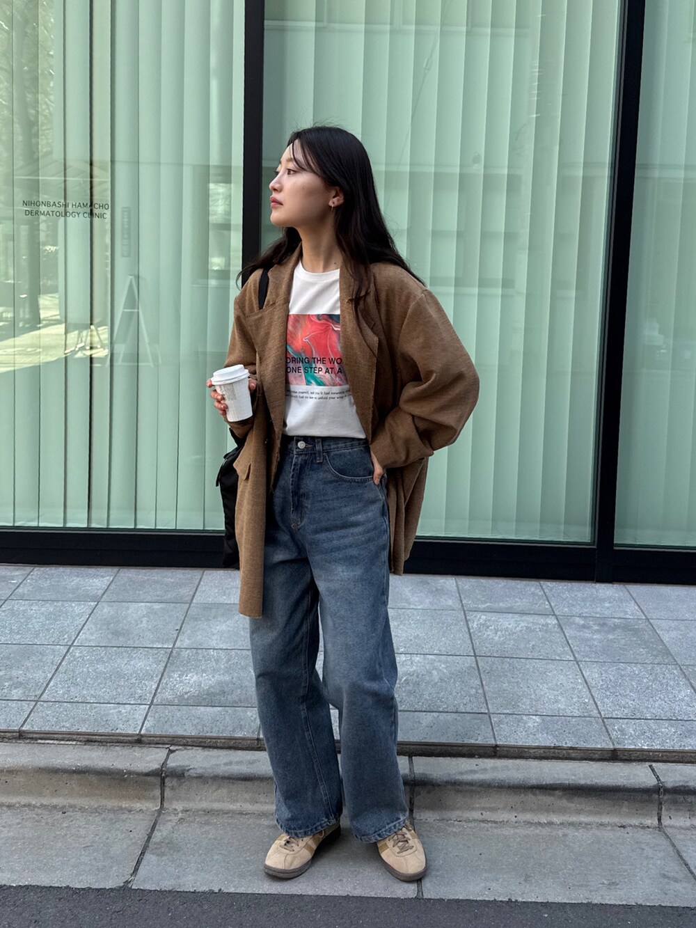 ブラウン系のテーラードジャケット、ホワイト系のTシャツ/カットソー、ブルー系のデニムパンツを着用したレディースの春コーディネートの2枚目の写真
