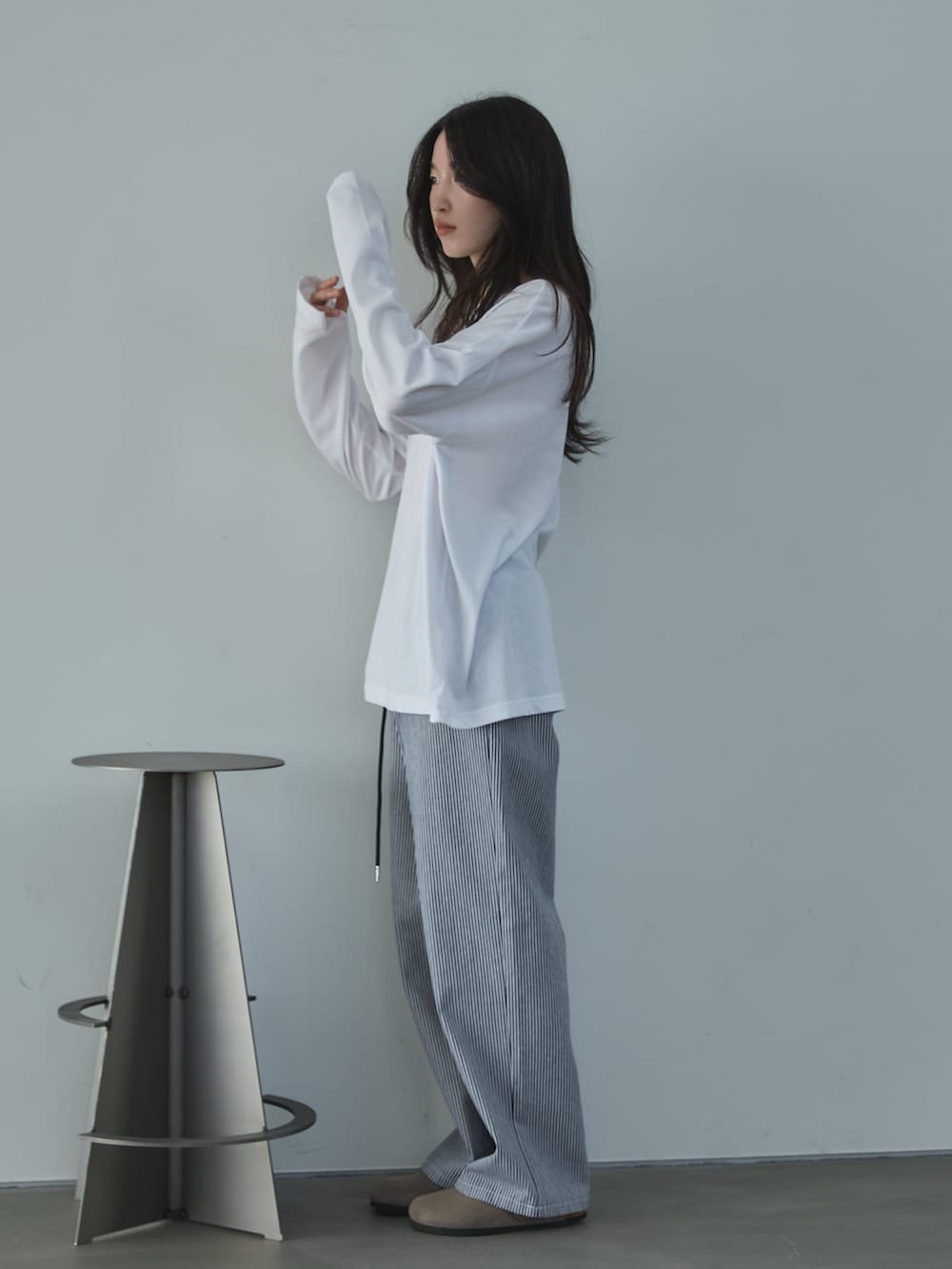 ホワイト系のTシャツ/カットソー、ホワイト系のデニムパンツ、ベージュ系のサンダルを着用したレディースの冬コーディネートの2枚目の写真