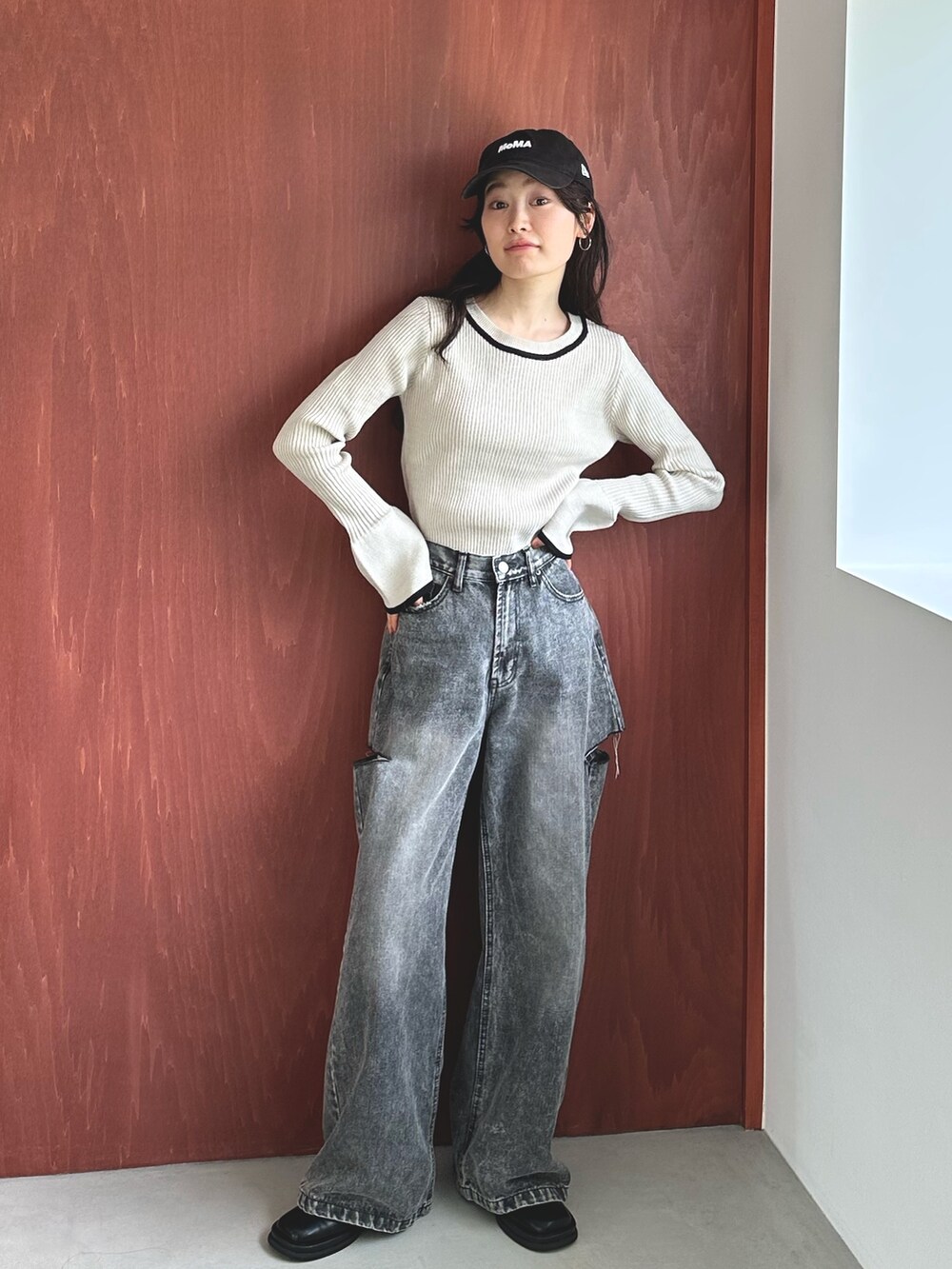 ブラック系のデニムパンツ、ブラック系のスリッポン、ホワイト系のニット/セーターを着用したレディースの秋コーディネートの3枚目の写真